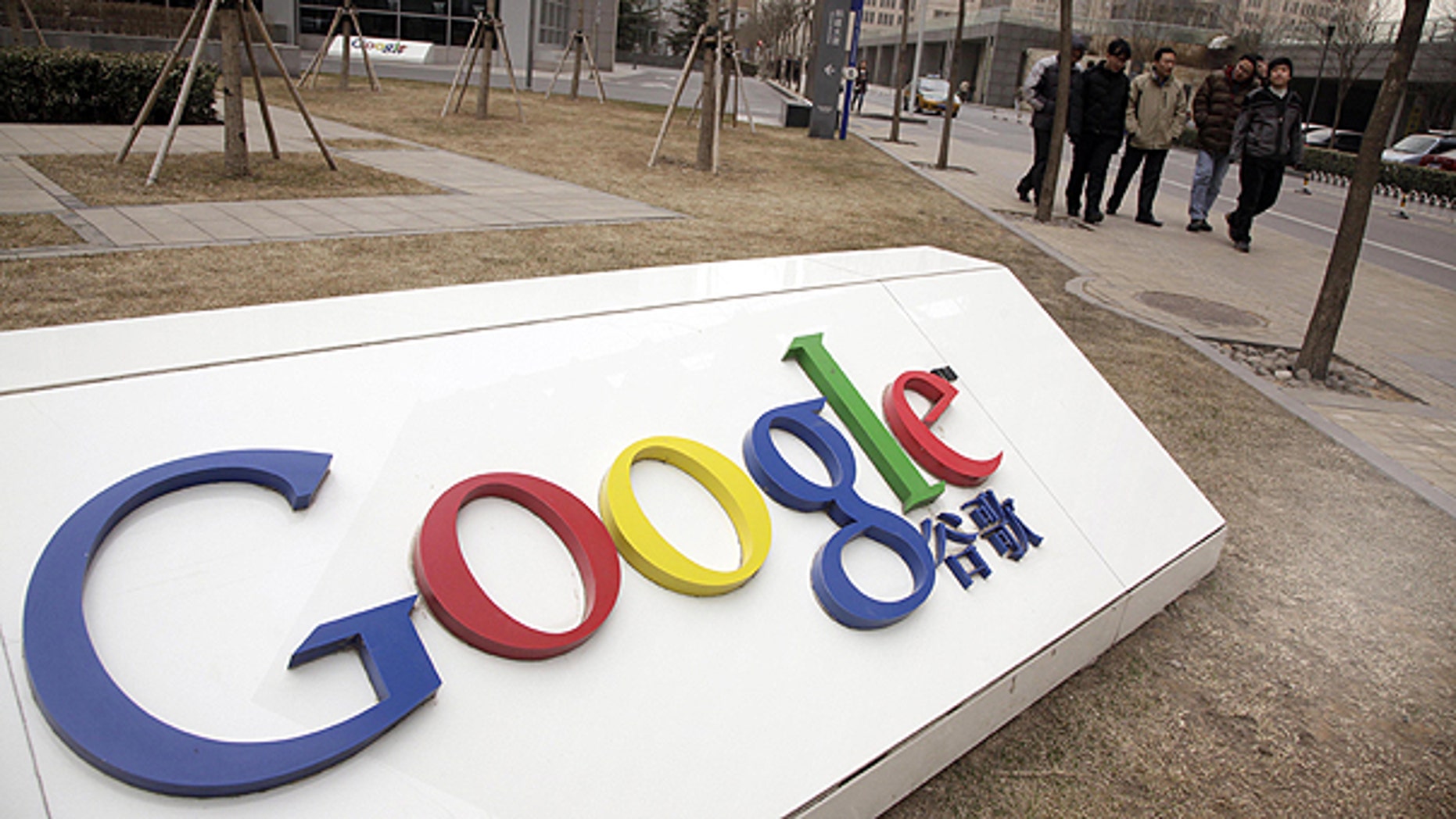 In a Monday March 22, 2010, file photo men walk past the Google China headquarters in Beijing, China.