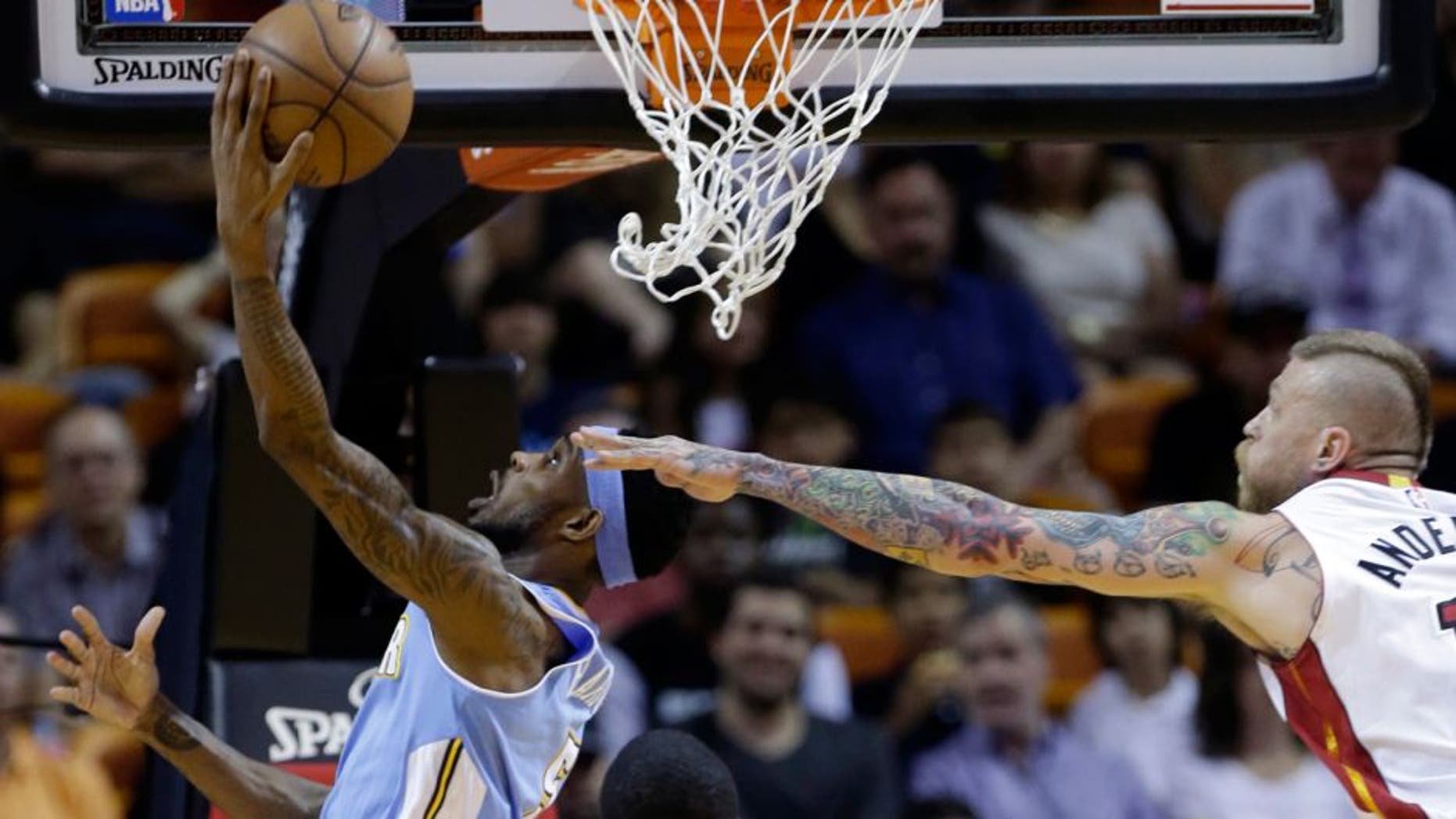 Denver Nuggets' Will Barton, left, attempts a shot against Miami Heat's Chris Andersen, right during the first half of an NBA basketball game, Friday, March 20, 2015, in Miami. (AP Photo/Lynne Sladky)