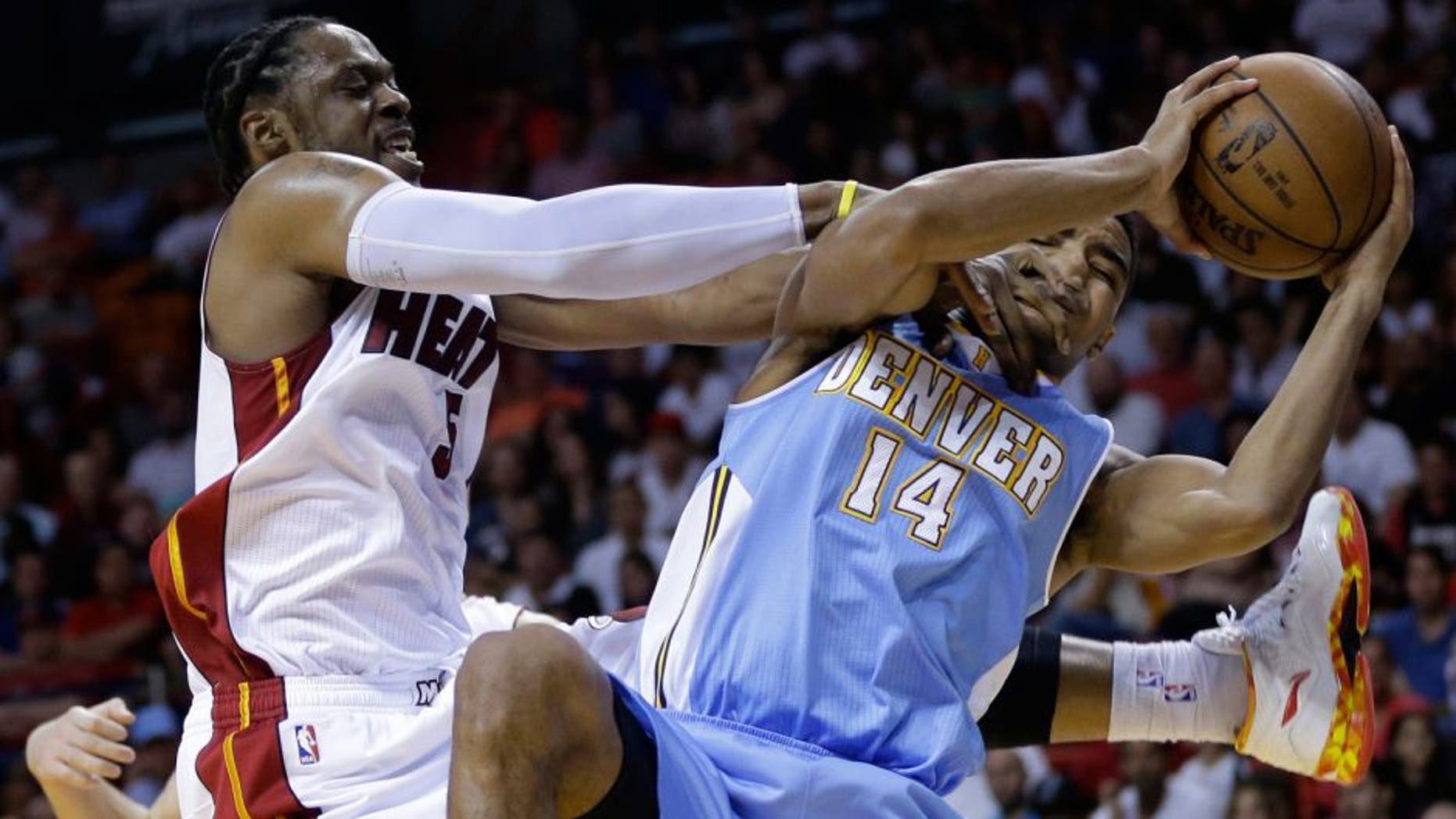 Miami Heat's Henry Walker, left, forces a jump ball as he defends Denver Nuggets' Gary Harris (14) during the second half of an NBA basketball game, Friday, March 20, 2015, in Miami. The Heat defeated the Nuggets 108-91. (AP Photo/Lynne Sladky)