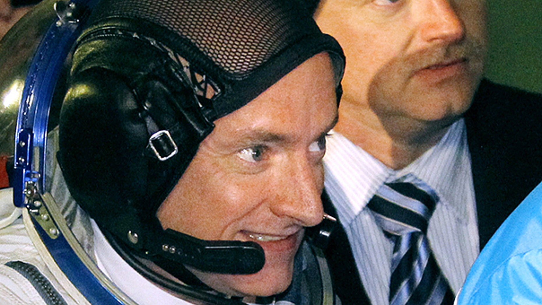 In this Oct. 8, 2010 file photo, U.S. astronaut Scott Kelly, a crew member of the mission to the International Space Station, left, accompanied by his brother, Mark Kelly, also an astronaut and husband of Rep. Gabrielle Giffords, right, walk to the rocket ahead of the launch of the Soyuz-FG rocket at the Russian-leased cosmodrome in Baikonur, Kazakhstan.