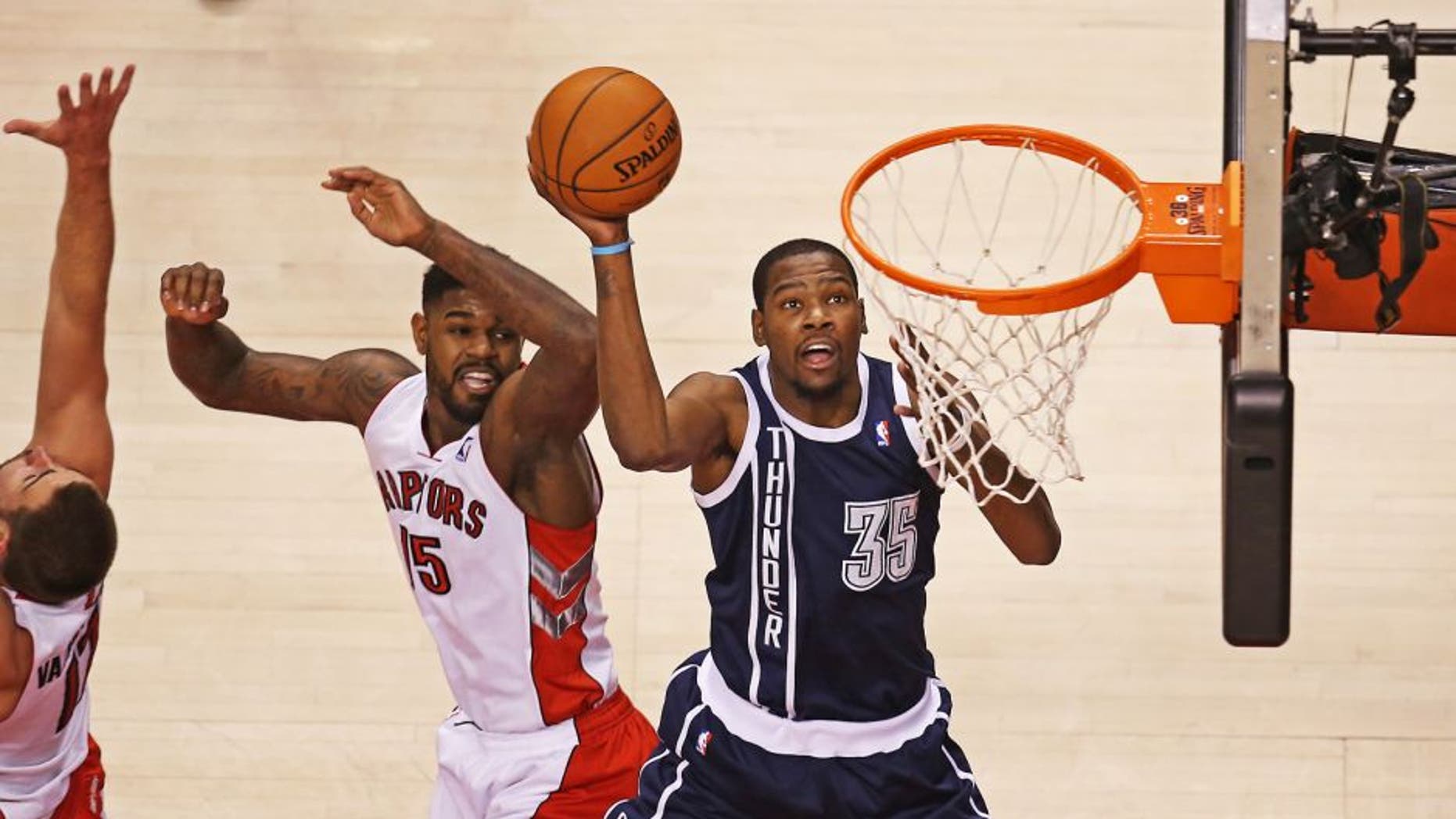 Mar 21, 2014; Toronto, Ontario, CAN; Oklahoma City Thunder forward Kevin Durant (35) goes to the basket and scores past Toronto Raptors forward Amir Johnson (15) at Air Canada Centre. Mandatory Credit: Tom Szczerbowski-USA TODAY Sports