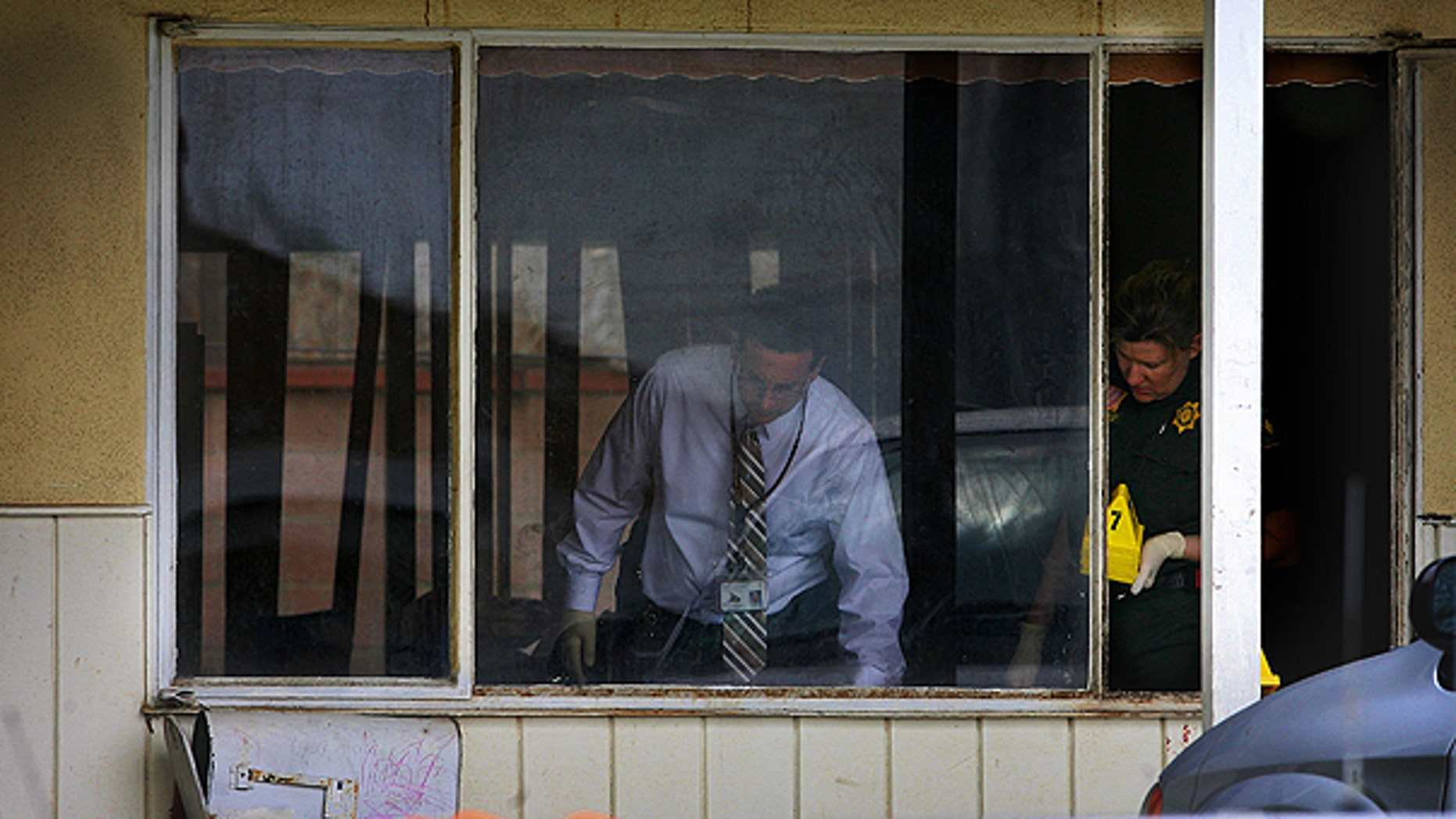 March 23: San Bernardino Sheriff's investigators and other personnel gather evidence at the scene where there were multiple stabbings in San Bernardino, Calif.