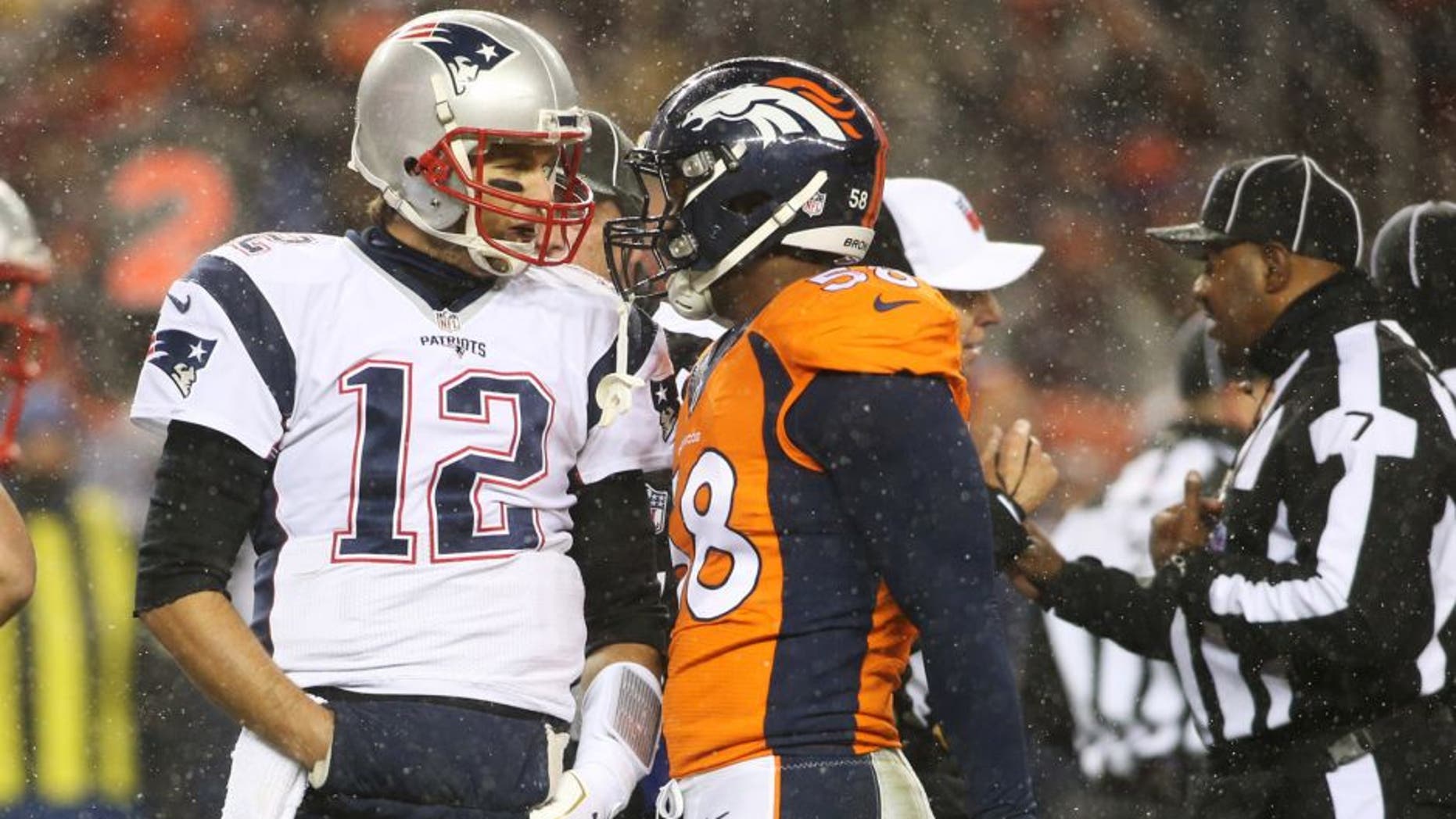 New England Patriots quarterback Tom Brady (12) and Denver Broncos outside linebacker Von Miller (58) have words during the first half at Sports Authority Field at Mile High. Mandatory Credit: