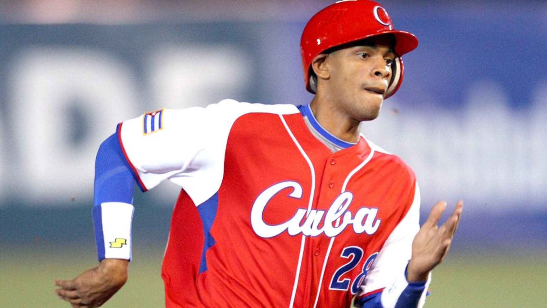 MEXICO CITY - MARCH 10: Second baseman Hector Olivera #28 of Cuba scores a run in the top of the seventh inning on a two-out double by Michel Enriquez #12 of Cuba that cuts the Australia lead to 4-3 during the Pool B, game four against Australia in the first round of the 2009 World Baseball Classic at Foro Sol Stadium in Mexico City, Mexico, Monday March 10, 2009. Cuba defeated Australia 5-4. (Photo by Paul Spinelli/WBCI/MLB Photos via Getty Images)
