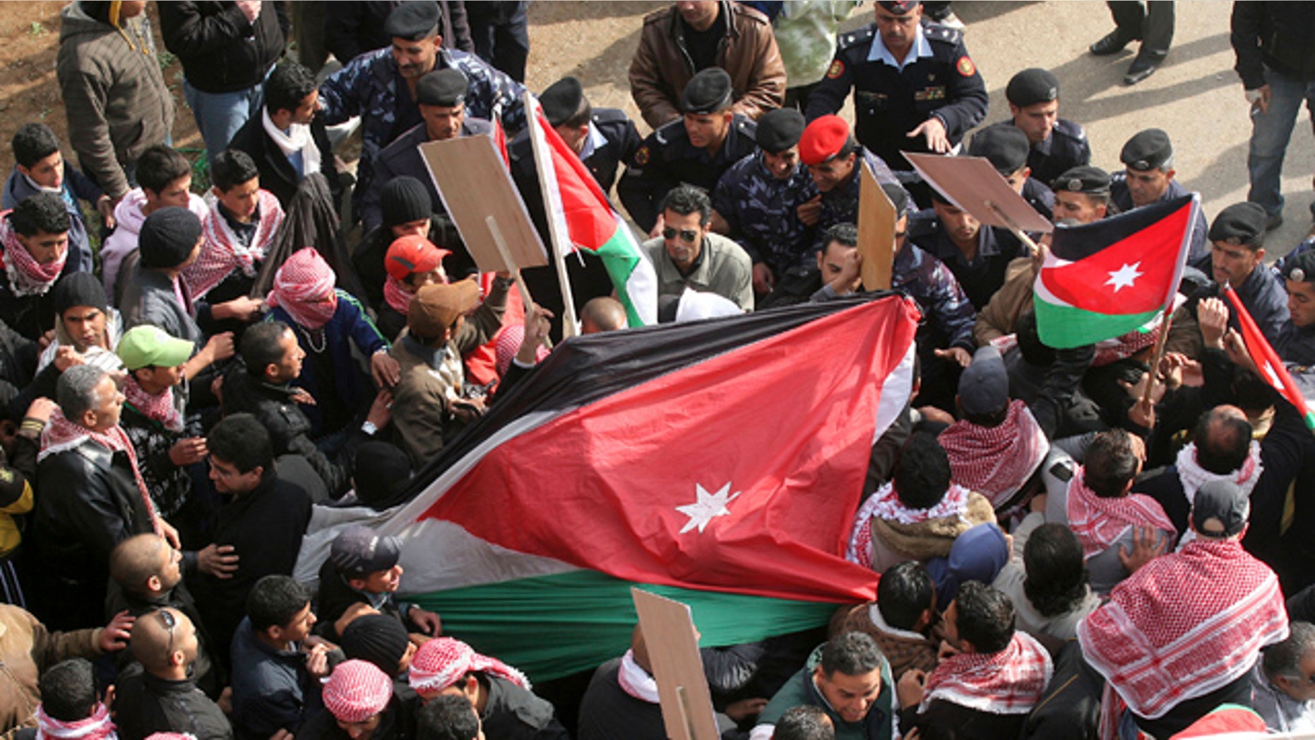 March 25: Jordanian pro-government supporters hold national flags during a rally in Amman, Jordan.
