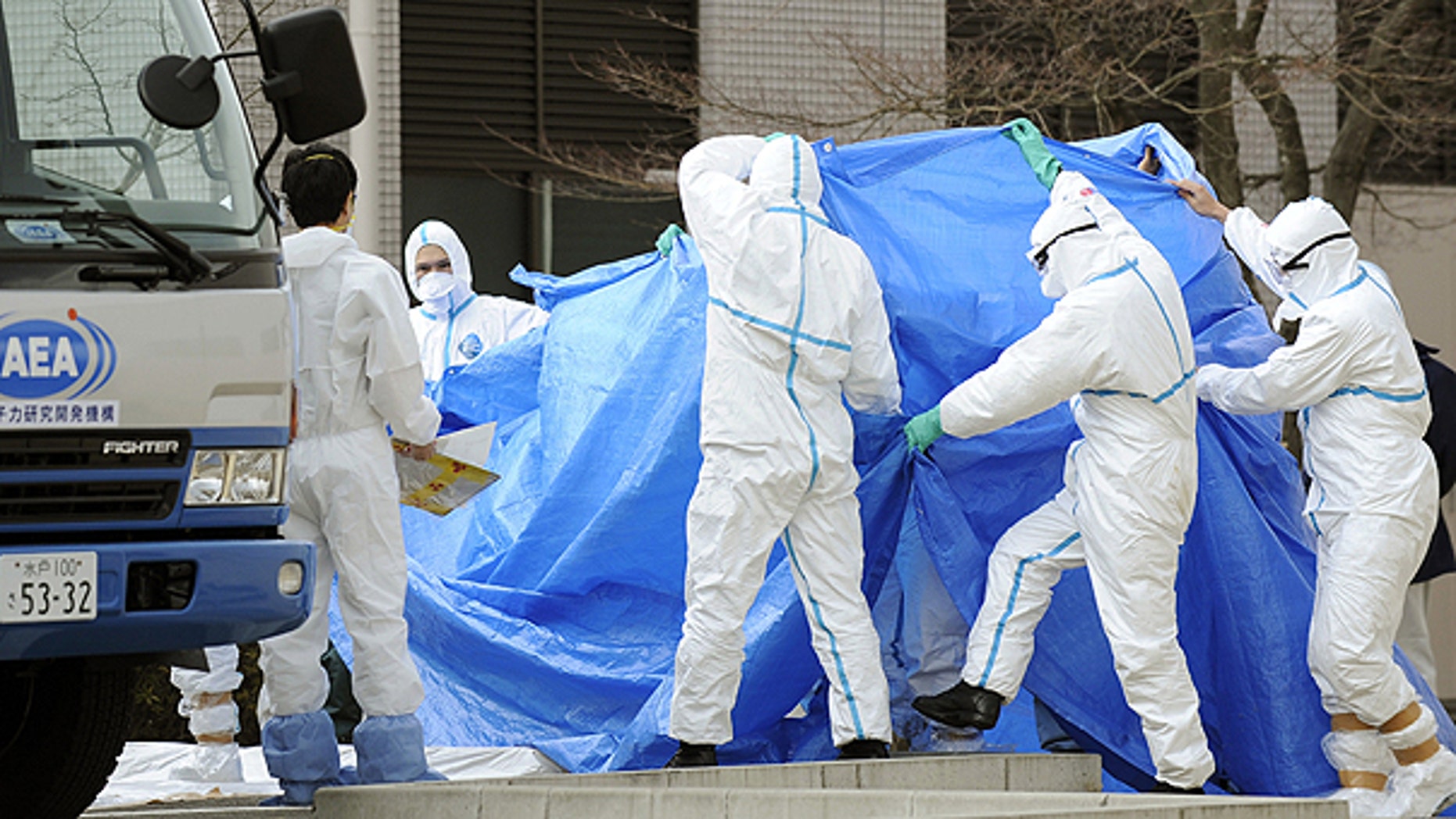 March 25: Workers, who stepped into radiation-contaminated water during Thursday's operation at the Fukushima Dai-ichi nuclear plant, are shielded with tarps before receiving decontamination treatment at a hospital in Fukushima, northeastern Japan.