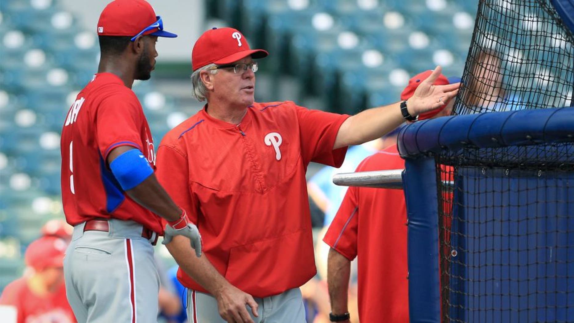 Interim manager Pete Mackanin #45 of the Philadelphia Phillies talks with Domonic Brown #9 during warm ups before their game against the Milwaukee Brewers at Miller Field on August 15, 2015 in Milwaukee, Wisconsin. The Brewers defeated the Phillies 4-2. (Photo by John Konstantaras/Getty Images)
