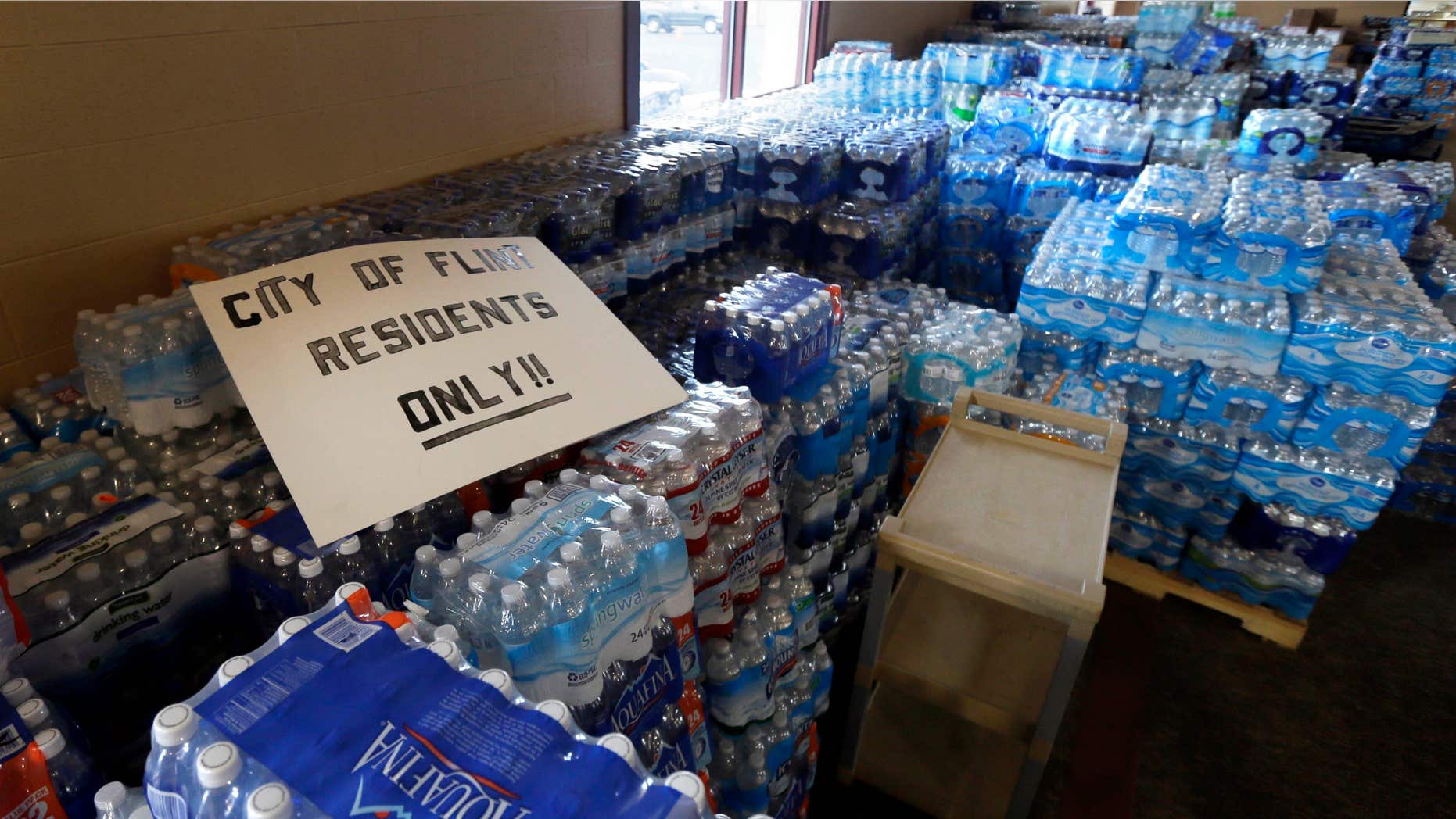 FILE - In this Friday, Feb. 5, 2016 file photo, hundreds of cases of bottled water are stored at Our Lady of Guadalupe Church in Flint, Mich.