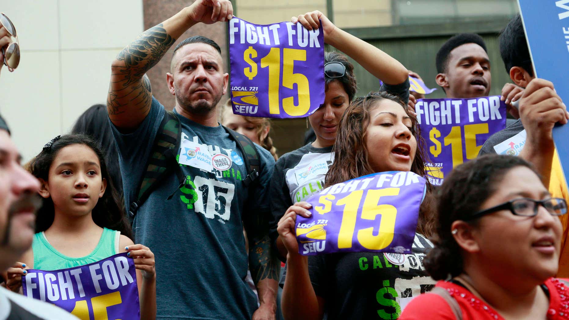 FILE - In this Tuesday, July 21, 2015 file photo, workers hold a rally in Los Angeles in support of the Los Angeles County Board of Supervisors' proposed minimum wage ordinance.