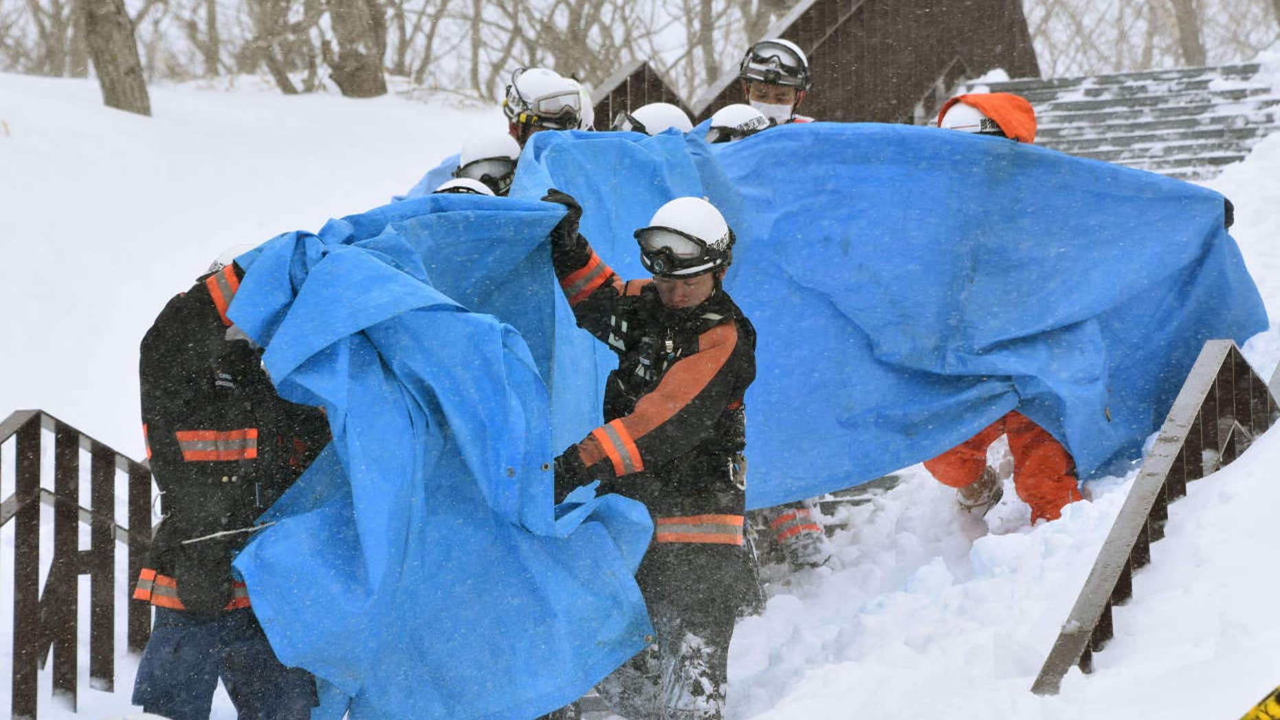 Rescuers carry the people who got injured in an avalanche at a ski resort in Nasu, Tochigi prefecture, Monday, March 27, 2017.