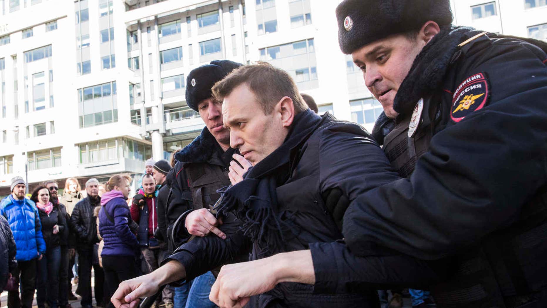 In this photo provided by Evgeny Feldman, Alexei Navalny is detained by police in downtown Moscow, Russia, Sunday, March 26, 2017.
