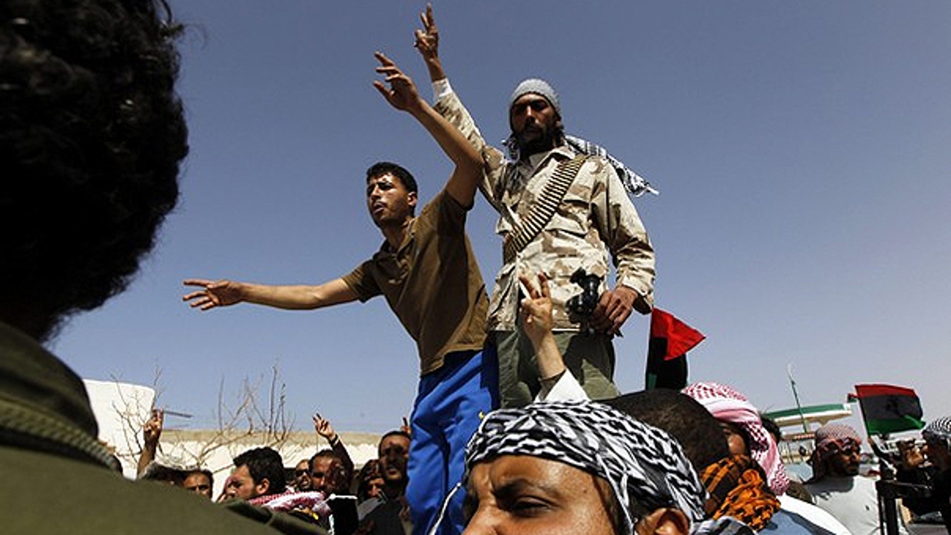 March 28: Libyan rebels react after they found a dead body in the town of Harwa.