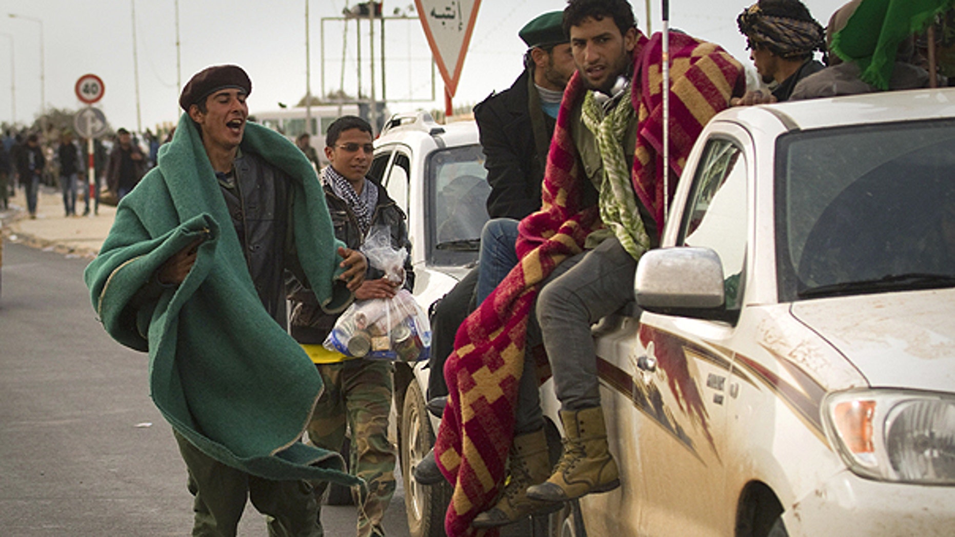 March 29: Libyan rebels run with their belongings as they leave Ras Lanouf, 250 km east of Sirte, central Libya.
