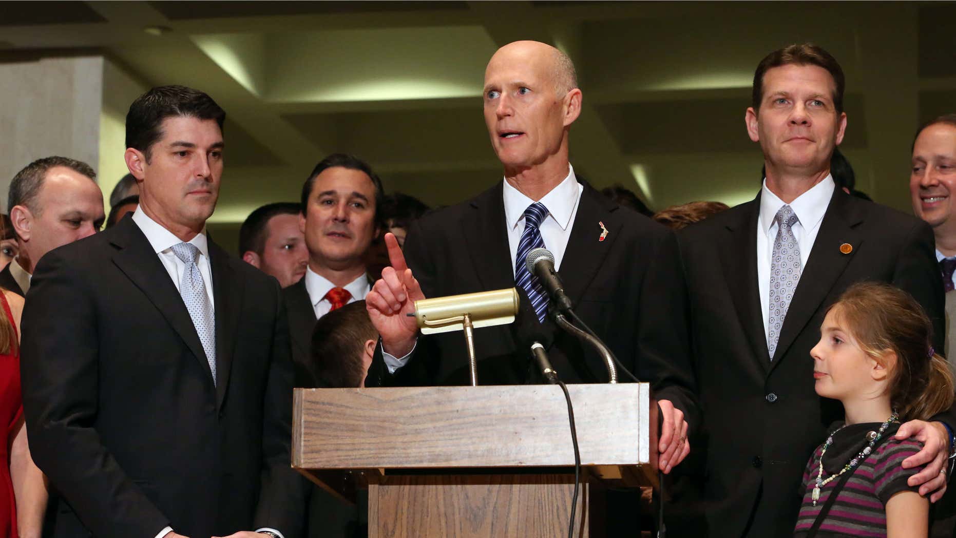 Gov. Rick Scott addresses the crowd flanked by House Speaker Steve Crisafulli, R-Merritt Island, left, and Senate President Andy Gardiner, R-Orlando, at the end of session, Friday, March 11, 2016, in Tallahassee, Fla.