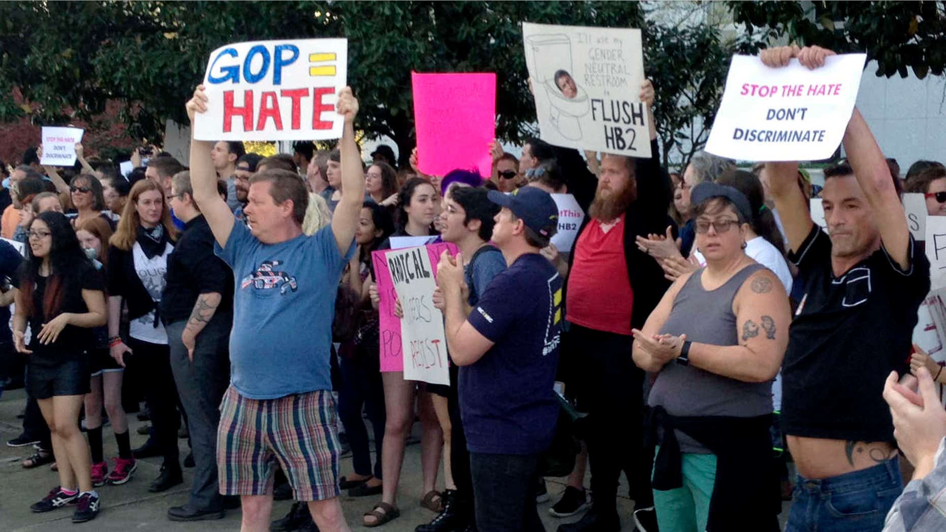 People protest outside the North Carolina Executive Mansion in Raleigh, N.C., Thursday, March 24, 2016. North Carolina legislators decided to rein in local governments by approving a bill Wednesday that prevents cities and counties from passing their own anti-discrimination rules.