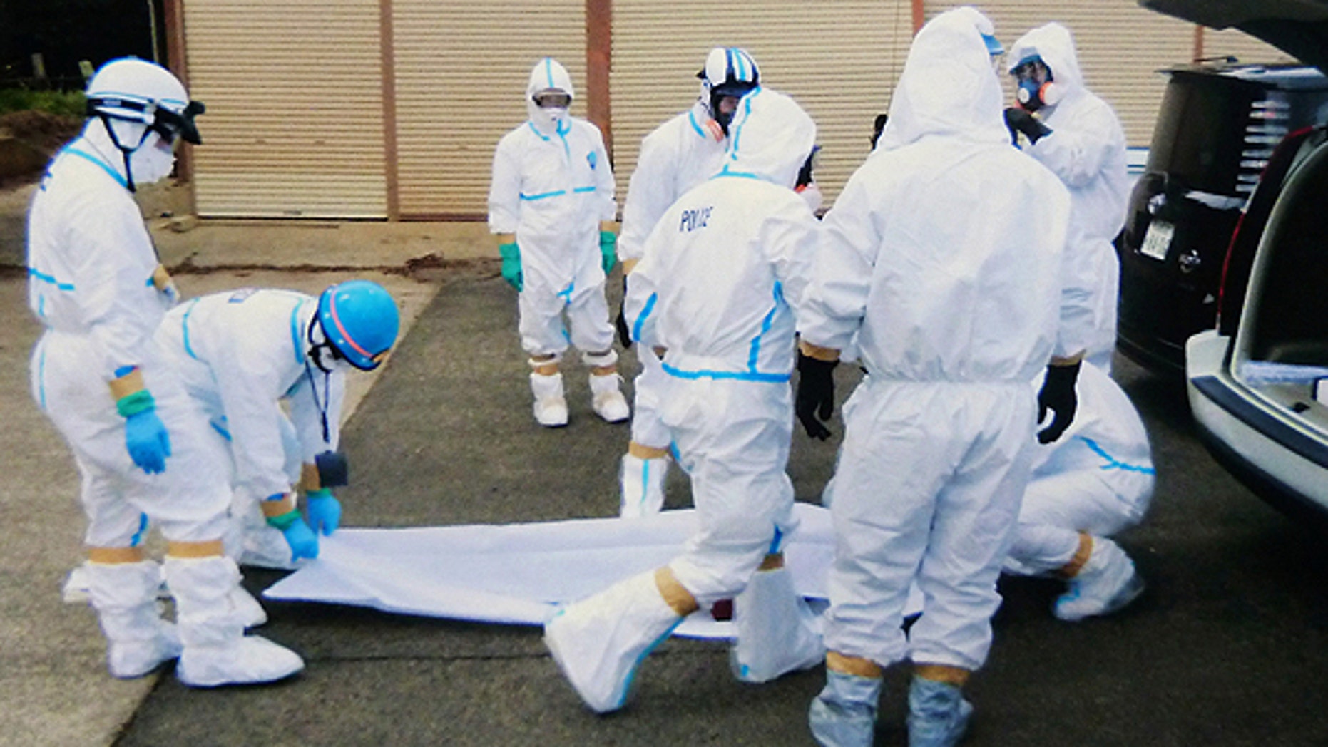 March 27: Police officers in protective suits surround a body found following the March 11 earthquake within 5 kilometers from the crippled Fukushima Dai-Ichi nuclear plant in Okumamachi, Fukushima Prefecture, northern Japan.