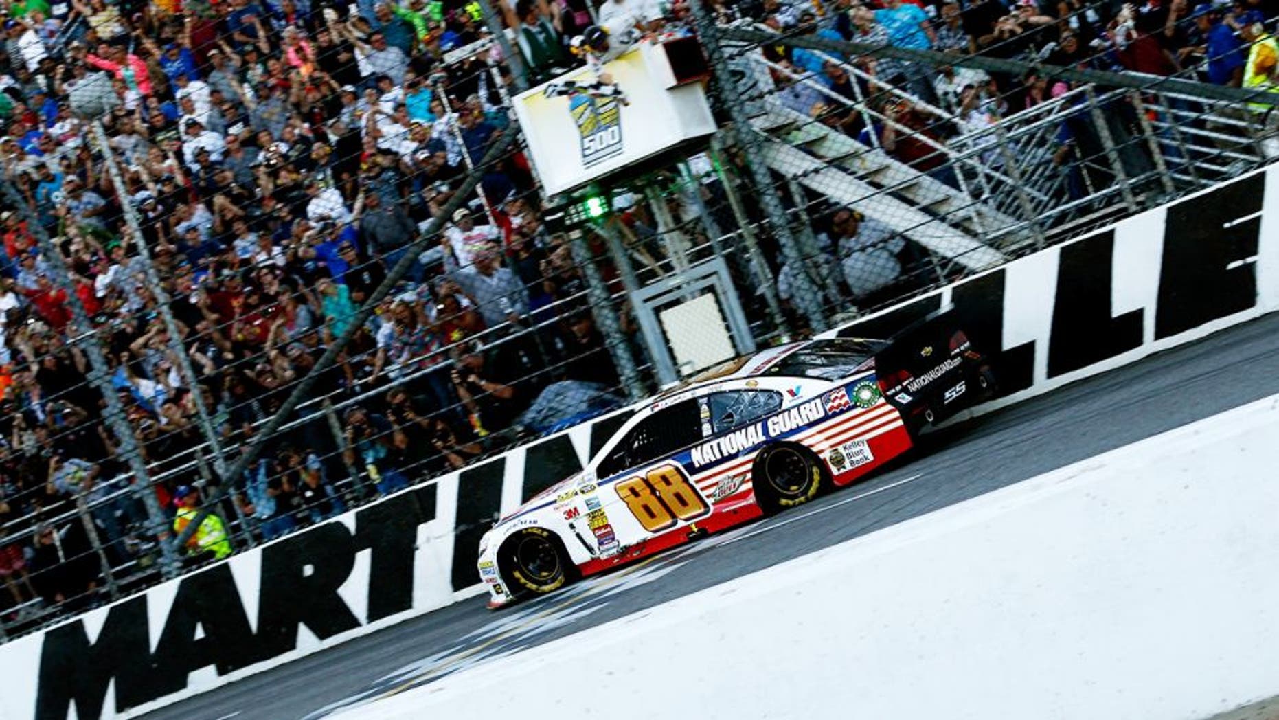 MARTINSVILLE, VA - OCTOBER 26: Dale Earnhardt Jr., driver of the #88 National Guard Chevrolet, takes the checkered flag to win the NASCAR Sprint Cup Series Goody's Headache Relief Shot 500 at Martinsville Speedway on October 26, 2014 in Martinsville, Virginia. (Photo by Jeff Zelevansky/Getty Images)