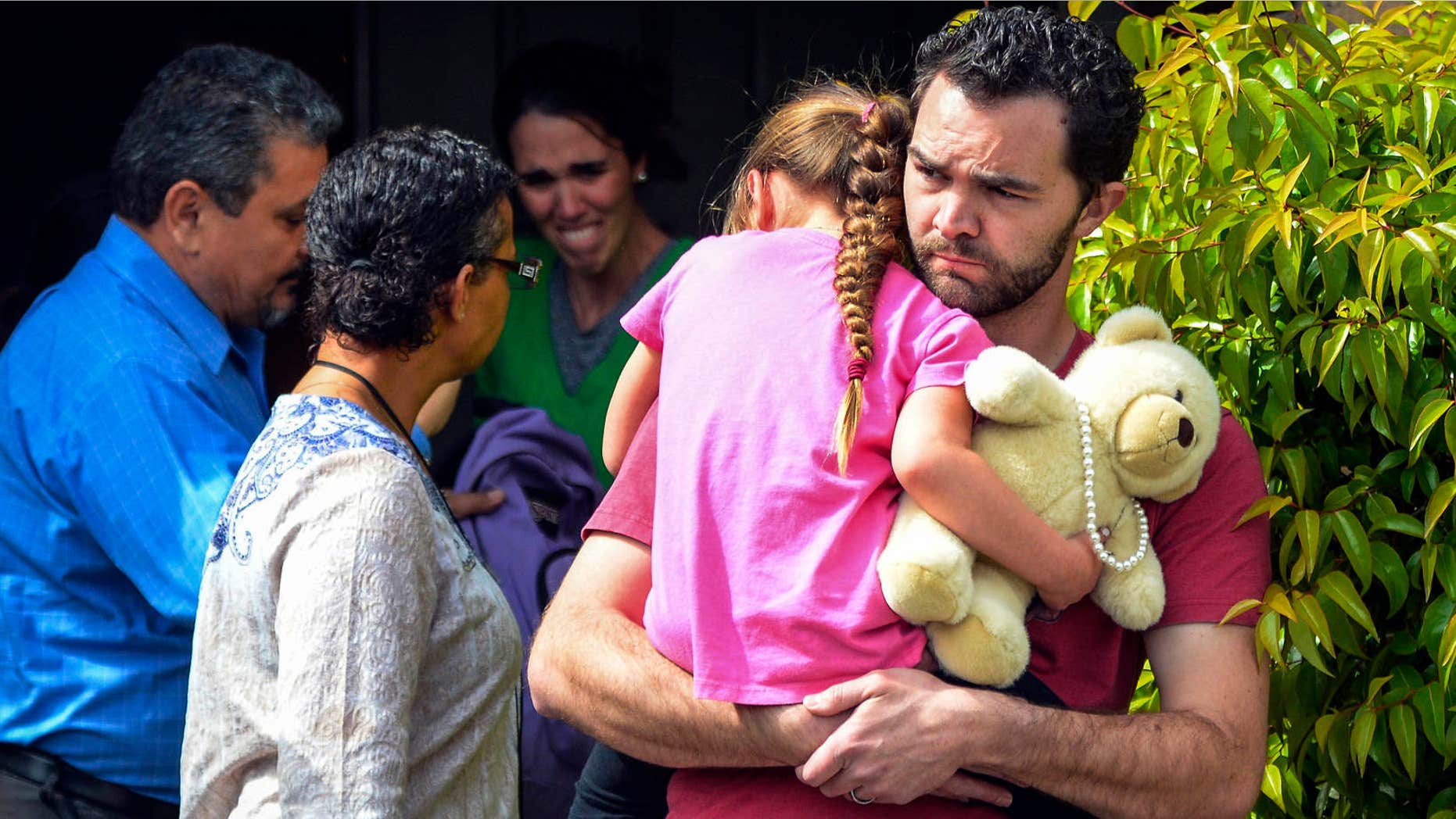 FILE - In this March 21, 2016 file photo, Rusty Page carries Lexi while Summer Page, in the background, cries as members of family services, left, arrive to take Lexi away from her foster family in Santa Clarita, Calif.