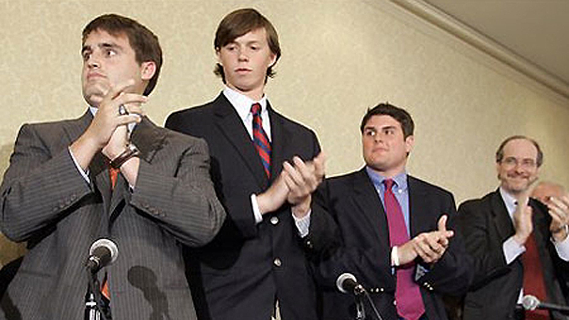 In this April 11, 2006, file photo, from left, David Evans, Collin Finnerty, Reade Seligmann, and lawyer Jim Cooney, right, applaud during a news conference in Raleigh, N.C.
