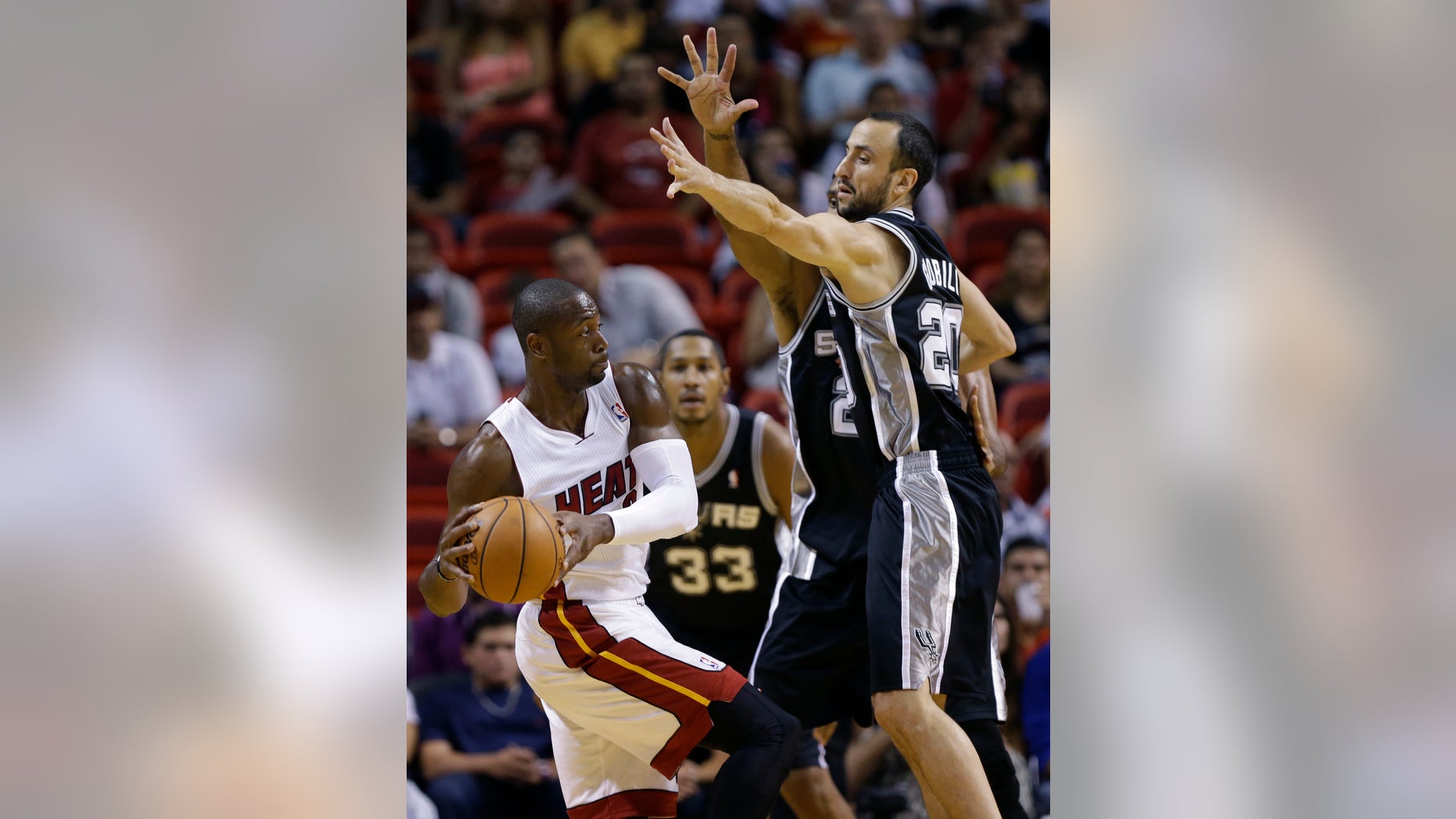 Miami Heat's Dwyane Wade (3) looks to pass as San Antonio Spurs' Manu Ginobili (20) defends during the first half of an NBA preseason basketball game, Saturday, Oct. 19, 2013, in Miami. (AP Photo/Lynne Sladky)