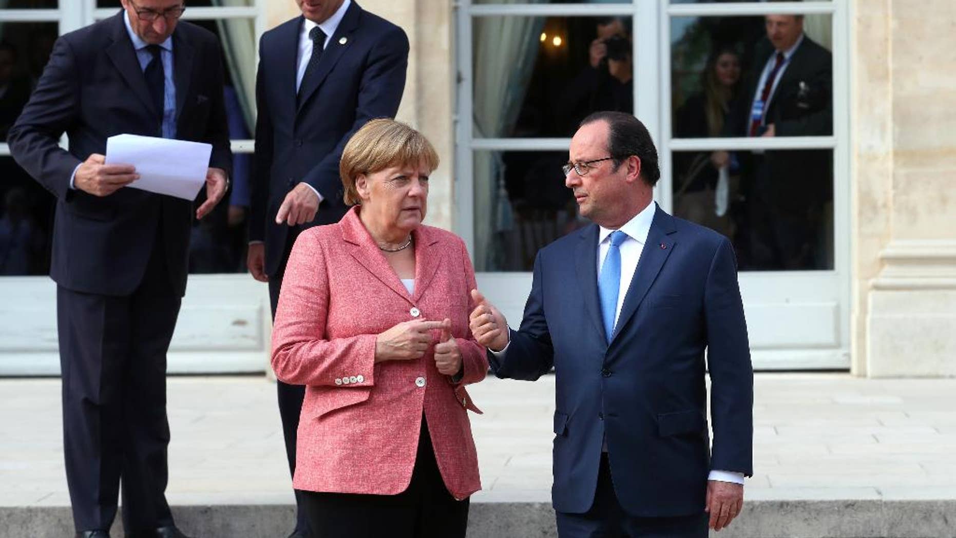 France's President Francois Hollande, right, and German Chancellor Angela Merkel arrive to pose for a family photo during the Balkans summit, at the Elysee Palace, in Paris, Monday, July 4, 2016.The leaders of France, Germany, Italy and Balkan nations are meeting to better prevent extremists from sneaking in with migrants who are moving west across Europe. (AP Photo/Thibault Camus, Pool)