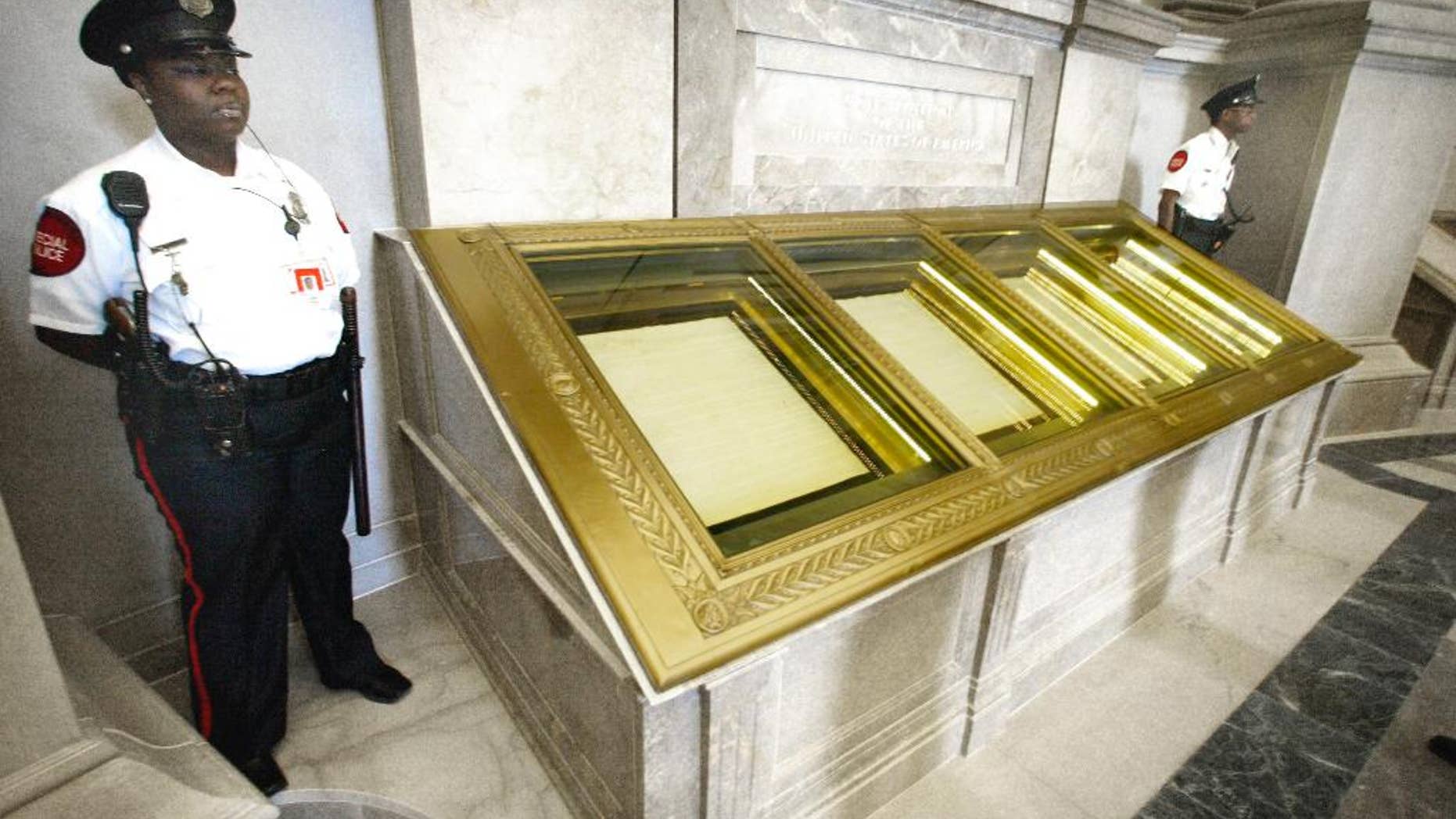 FILE - In this Sept. 16, 2003 file photo, guards stand next to the U.S. Constitution in the Rotunda of the National Archives in Washington. If there’s one thing Republicans and Democrats can agree on when it comes to guns, it’s their proclaimed respect for the Second Amendment. Lawyers, scholars, judges, politicians and ordinary Americans have been puzzling over that question for much of two centuries. (AP Photo/Ron Edmonds, File)