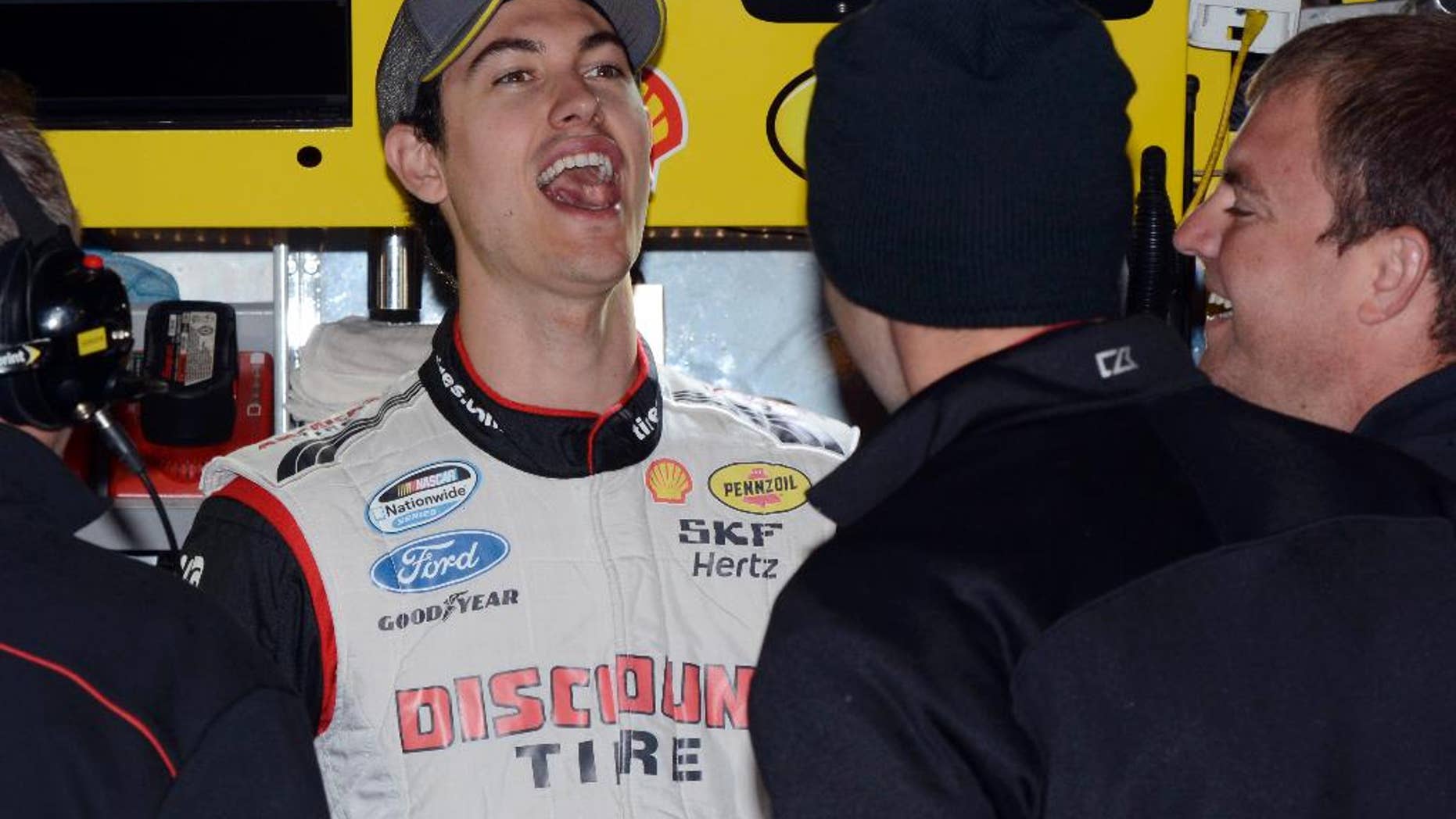 Driver Joey Logano shares a laugh with his crew in the garage during practice for Sunday's NASCAR Sprint Cup series auto race at the Texas Motor Speedway in Fort Worth, Texas, Saturday, Nov. 1, 2014. (AP Photo/Larry Papke)