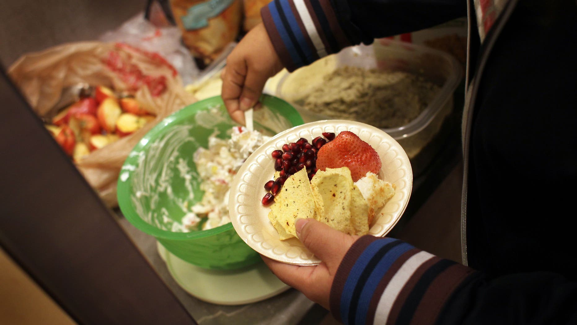 AURORA, CO - NOVEMBER 20: A child takes a plate of healthy snacks during the Shapedown program for overweight adolescents and children on November 20, 2010 in Aurora, Colorado. The 10-week family-centered program held by the Denver area Children's Hospital teaches youth and their parents ways to lead a healthier more active lifestyle, as a longer lasting weight-loss alternative to dieting. Nationally, some 15 percent of children are overweight or obese, as are some 60 percent of adults. (Photo by John Moore/Getty Images)