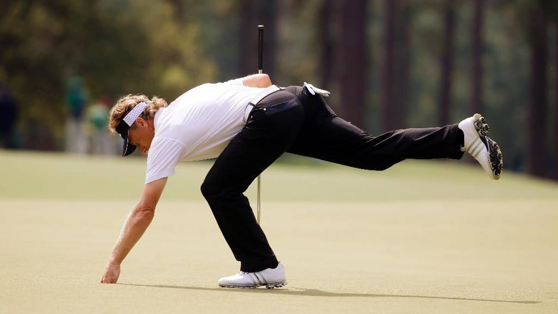 Bernhard Langer, of Germany, gets his ball out of the cup after putting on the eighth green during the second round of the Masters golf tournament Friday, April 11, 2014, in Augusta, Ga. (AP Photo/Darron Cummings)
