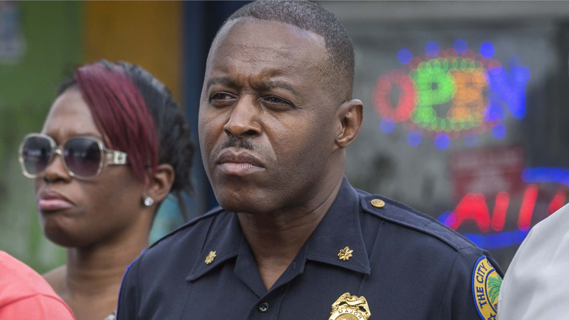 In this Jan. 2, 2016, photo, Miami Police Maj. Delrish Moss stands among the Miami-Dade officials who announced the arrest of Willie "Pee Wee" Wilcher in Liberty City, Fla.