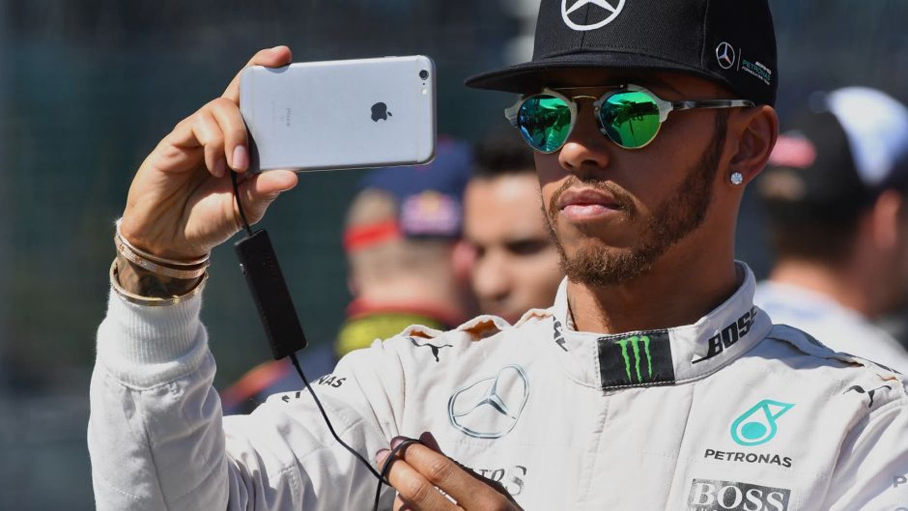 Mercedes AMG Petronas F1 Team's British driver Lewis Hamilton takes a photo on his phone ahead of the Formula One Australian Grand Prix in Melbourne on March 20, 2016. / AFP / Paul Crock / --IMAGE RESTRICTED TO EDITORIAL USE - STRICTLY NO COMMERCIAL USE-- (Photo credit should read PAUL CROCK/AFP/Getty Images)