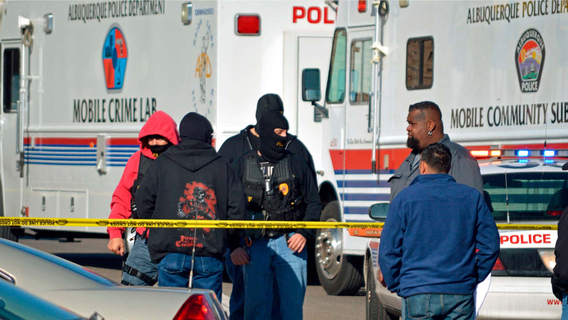 FILE - This Jan. 9, 2015 file photo, Investigators search a busy intersection in Albuquerque, N.M., after police say an undercover detective shot another undercover detective during a drug sting.