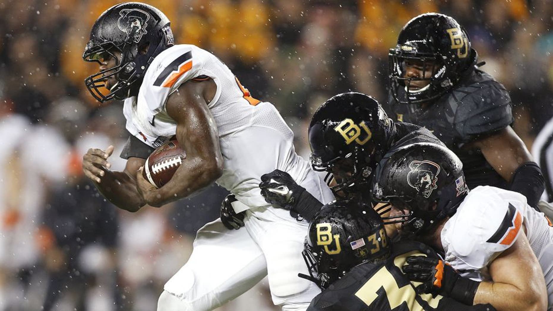 Nov 22, 2014; Waco, TX, USA; Oklahoma State Cowboys running back Rennie Childs (23) is gang tackled with the gal in the third quarter at McLane Stadium. Baylor beat Oklahoma State 49-28. Mandatory Credit: Tim Heitman-USA TODAY Sports