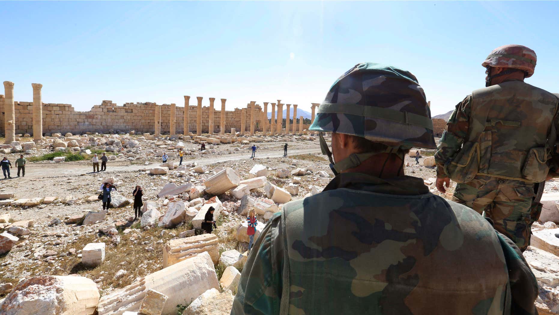 In this picture taken Friday, April 1, 2016, soldiers look over damage at the historical Bel Temple in the ancient city of Palmyra in the central city of Homs, Syria.