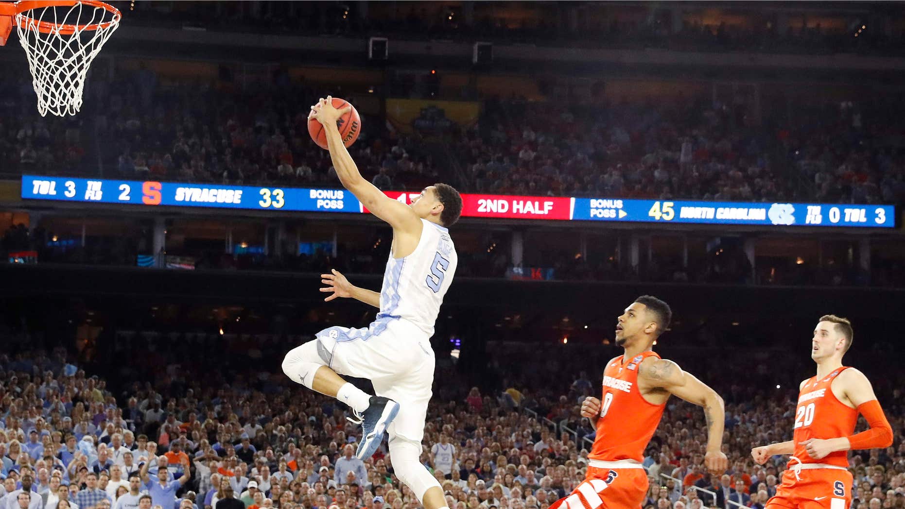 North Carolina guard Marcus Paige (5) leaps toward the goal as Syracuse forward Michael Gbinije (0) gives chase during the second half of the NCAA Final Four tournament college basketball semifinal game Saturday, April 2, 2016, in Houston.