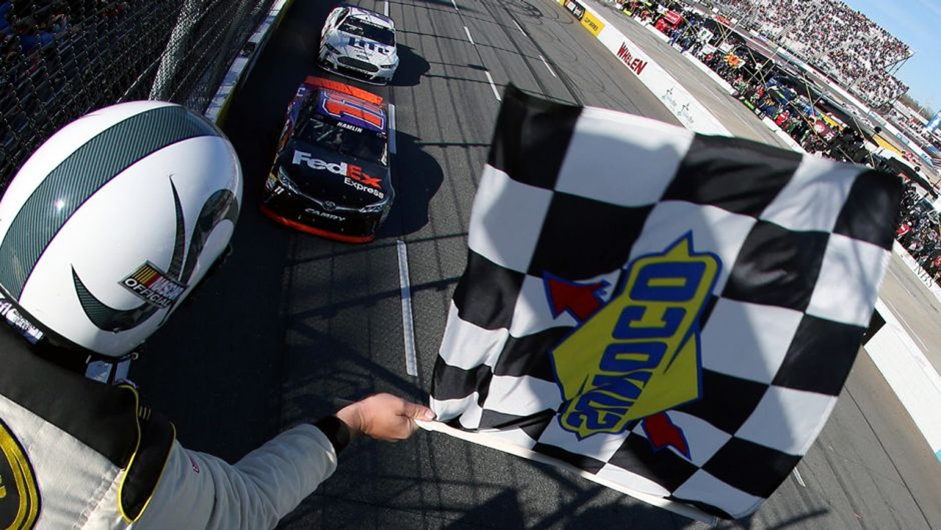 MARTINSVILLE, VA - MARCH 29: Denny Hamlin, driver of the #11 FedEx Express Toyota, takes the checkered flag to win the NASCAR Sprint Cup Series STP 500 at Martinsville Speedway on March 29, 2015 in Martinsville, Virginia. (Photo by Nick Laham/NASCAR via Getty Images)