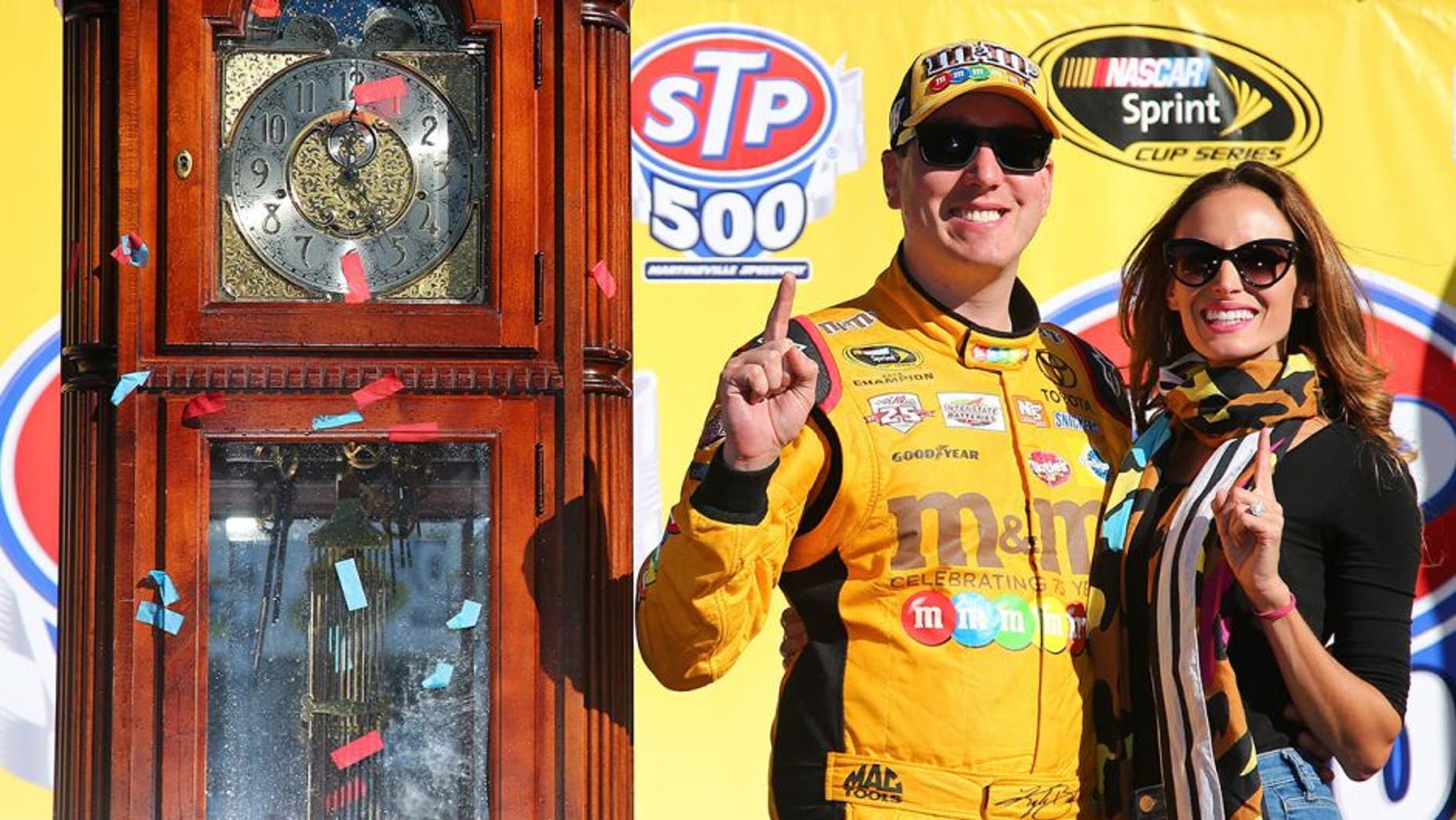 MARTINSVILLE, VA - APRIL 03: Kyle Busch, driver of the #18 M&M's 75th Anniversary Toyota, poses for a photo with his wife Samantha in Victory Lane ater winning the NASCAR Sprint Cup Series STP 500 at Martinsville Speedway on April 3, 2016 in Martinsville, Virginia. (Photo by Sarah Crabill/Getty Images)