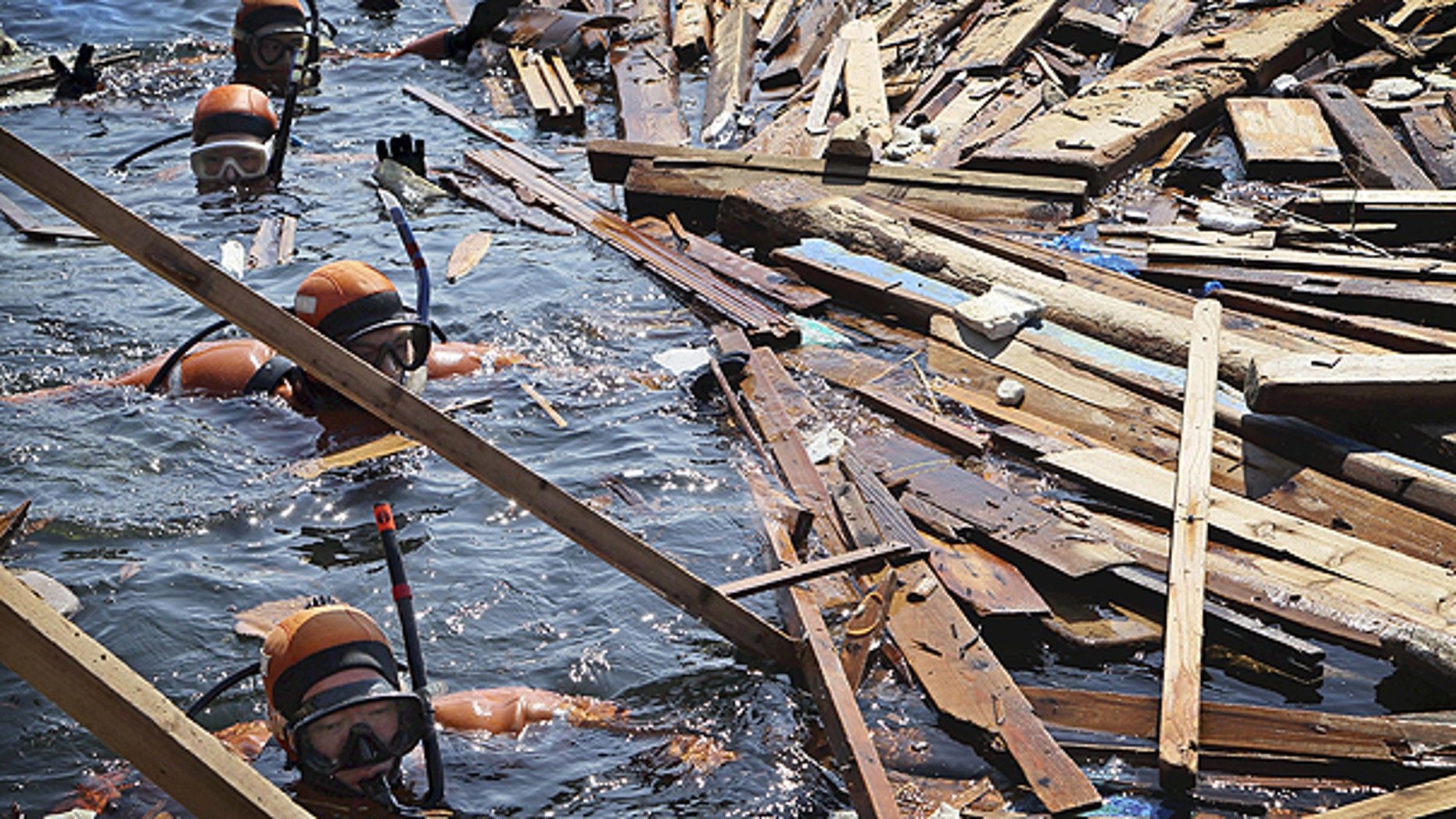 April 5: Scuba divers search for the bodies of missing people in water of Yoriiso fishing port in Ishinomaki, Miyagi Prefecture following the March 11 earthquake and tsunami hit northeastern Japan.