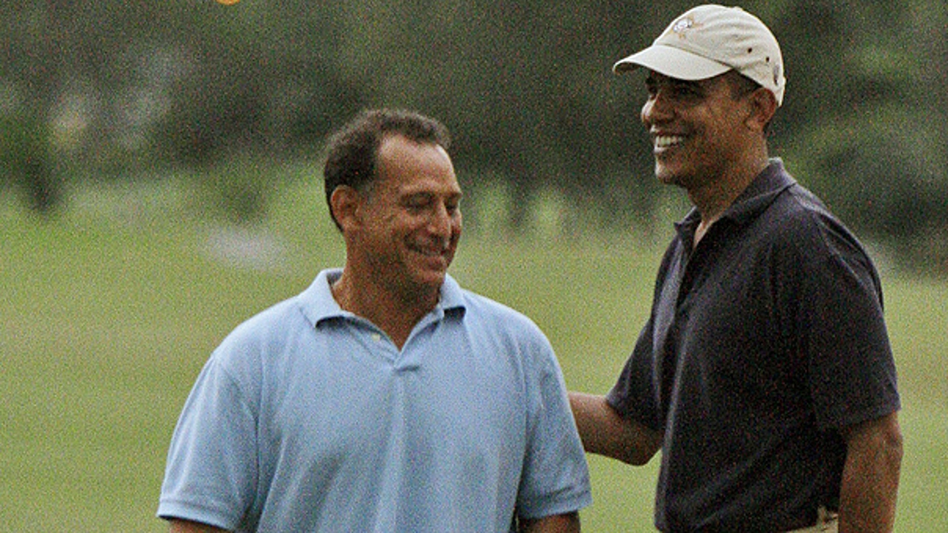 In this Dec. 31, 2009 file photo, President Obama, right, laughs with Bobby Titcomb on the 18th green as they play golf at Mid Pacific Country Club in Kailua, Hawaii.