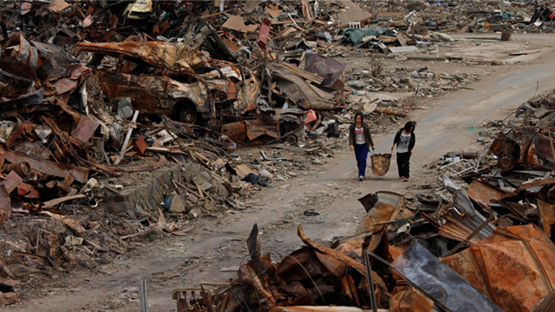 April 7: Two women walk past debris in an area devastated by the March 11 earthquake and tsunami in Ishinomaki, Miyagi Prefecture, northern Japan.