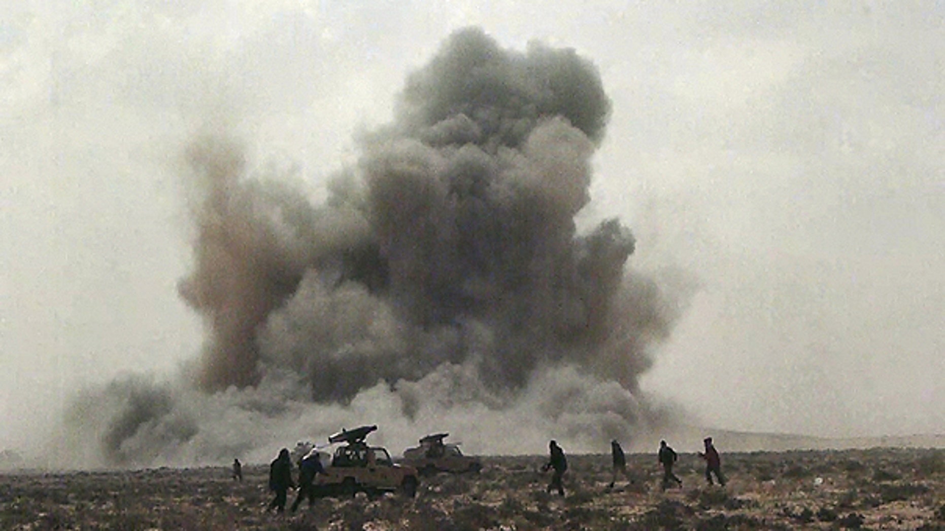 FILE: In this April 7, 2011, image made from television, a dust cloud is seen following the explosion of a missile, outside the strategic oil port of Brega, Libya.