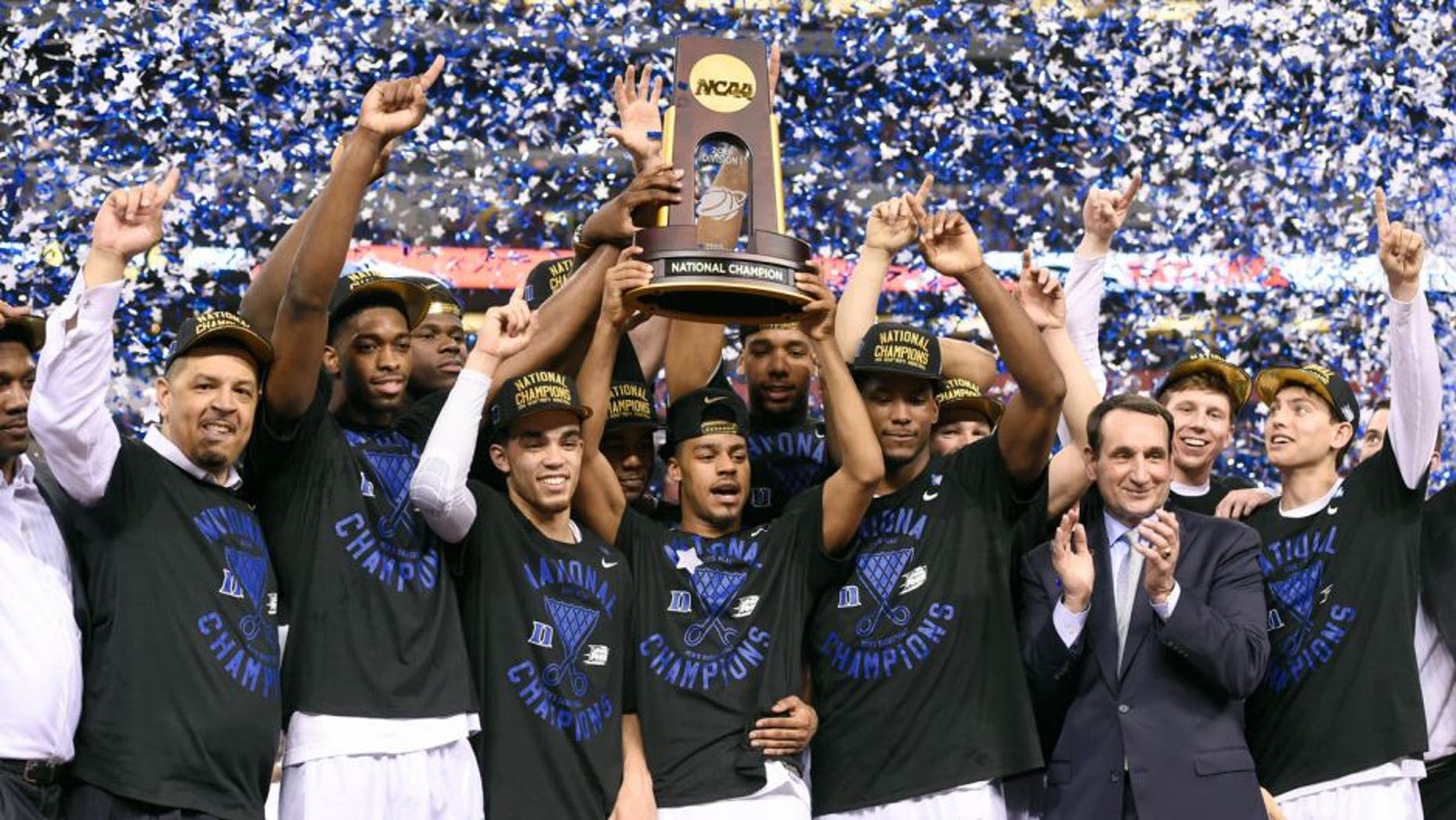 Apr 6, 2015; Indianapolis, IN, USA; Duke Blue Devils celebrate with the NCAA trophy on the podium after defeating the Wisconsin Badgers 68-63 in the 2015 NCAA Men's Division I Championship game at Lucas Oil Stadium. Mandatory Credit: Robert Deutsch-USA TODAY Sports