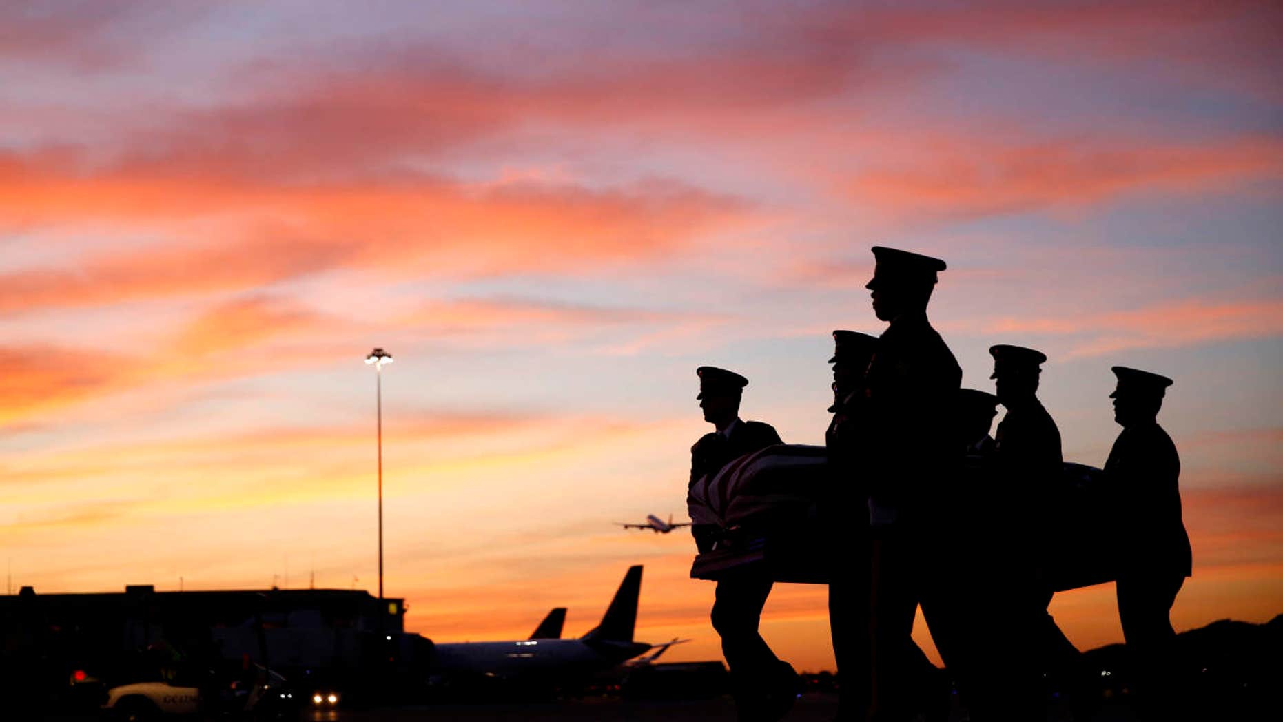 April 6, 2016: Servicemen carry a flag-covered casket containing the remains of Army Cpl. Robert Graham from a plane to a hearse at San Francisco International Airport.