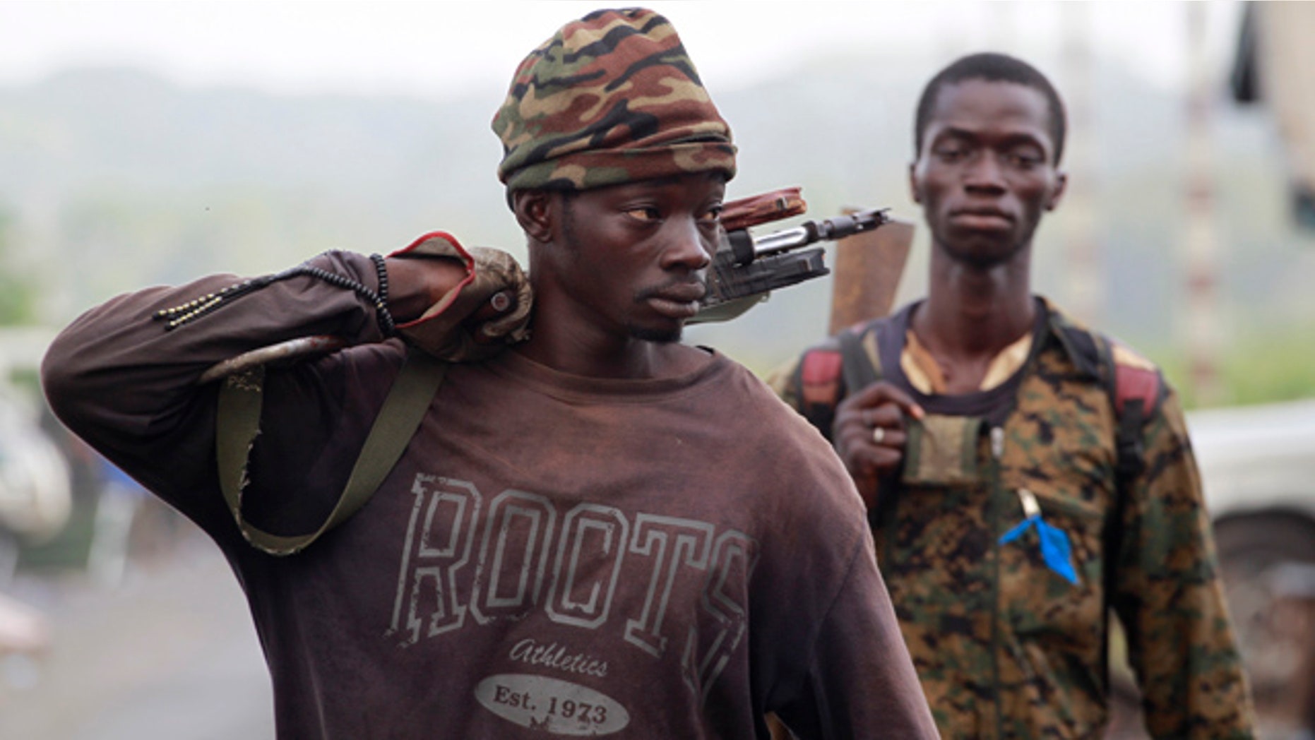April 8: Soldiers loyal to Alassane Ouattara carry their weapons as they walk through a republican forces operating base in the Youpougon neighborhood, on the outskirts of Abidjan, Ivory Coast.