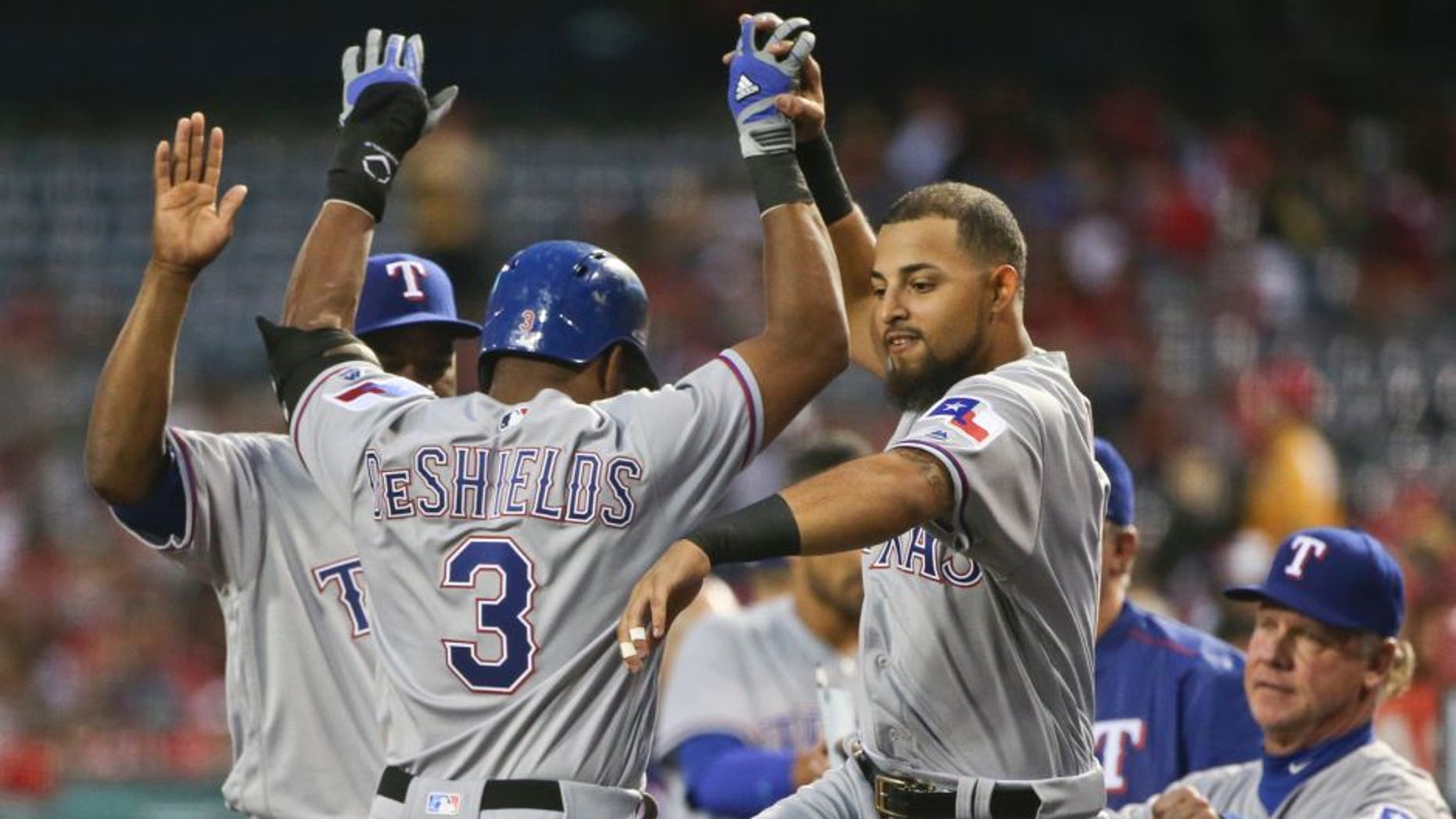 Texas Rangers' Rougned Odor greets Delino DeShields after DeShields scored in their three-run first inning against the Los Angeles Angels in a baseball game Friday, April 8, 2016, in Anaheim, Calif. (AP Photo/Lenny Ignelzi)