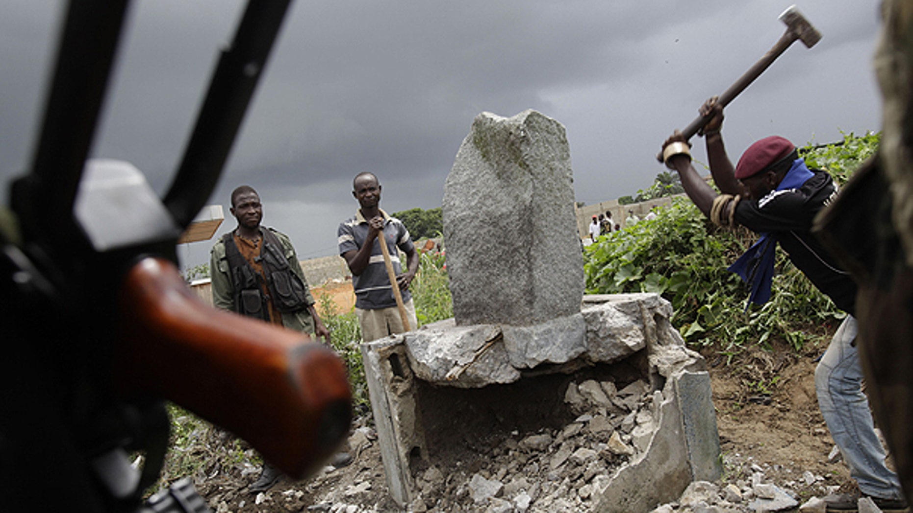 April 10: A soldier allied with Alassane Ouattara knocks down a monument believed to mystically provide strength and support to Laurent Gbagbo, in the Youpougon neighborhood of Abidjan, Ivory Coast.