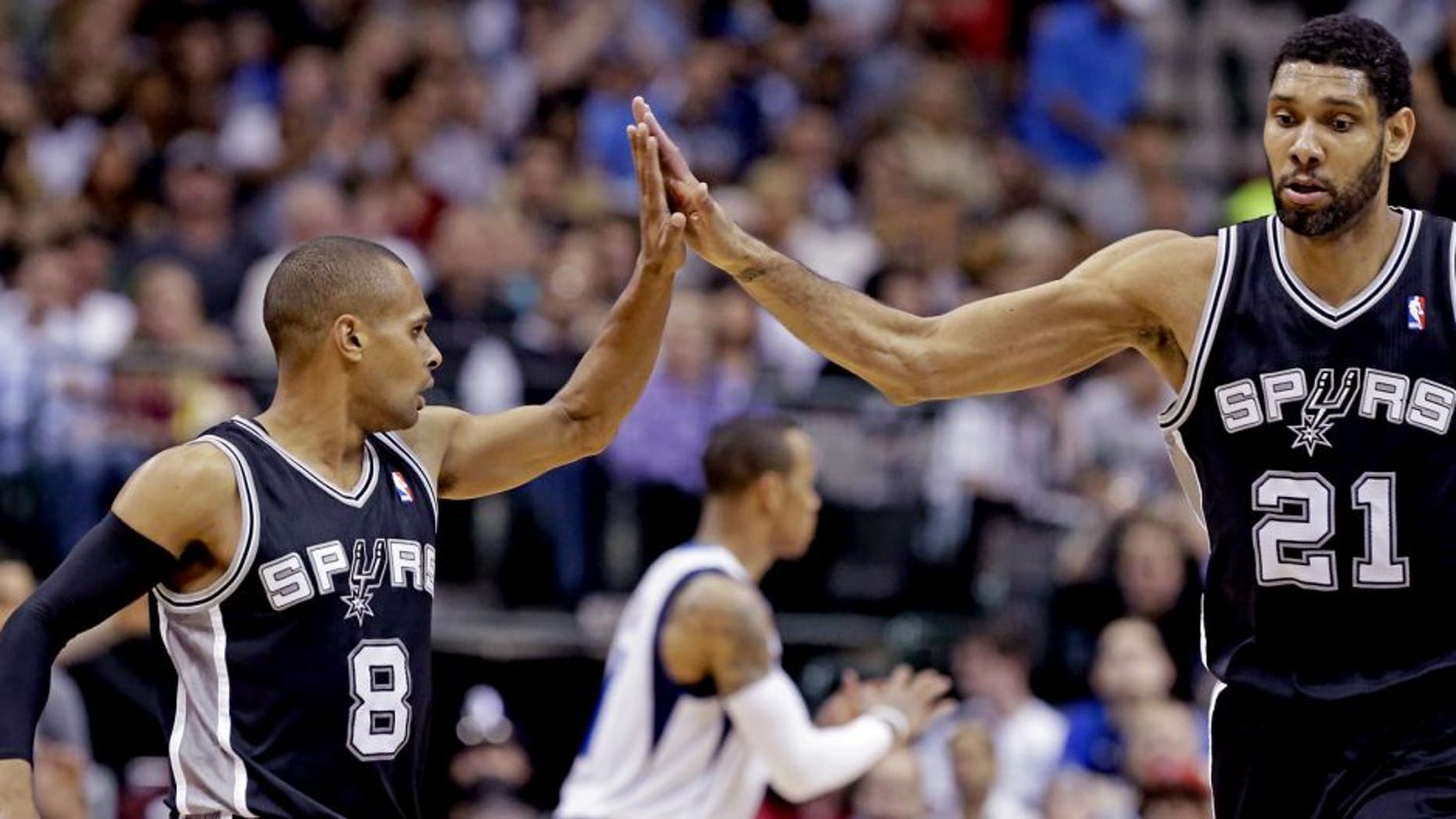 San Antonio Spurs guard Patty Mills (8) receives congratulations from Tim Duncan (21) during the second half an NBA basketball game against the Dallas Mavericks on Thursday, April 10, 2014, in Dallas. The Spurs won 109-100. (AP Photo/LM Otero)