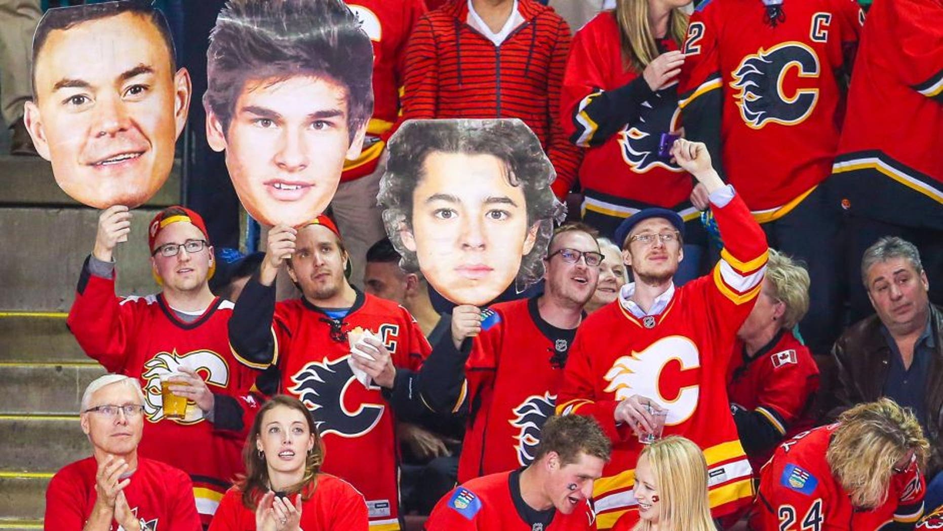 Apr 9, 2015; Calgary, Alberta, CAN; Calgary Flames fans hold cardboard cutouts of Jiri Hudler (not pictured), Sean Monahan (not pictured) and Johnny Gaudreau (not pictured) during the first period against the Los Angeles Kings at Scotiabank Saddledome. Mandatory Credit: Sergei Belski-USA TODAY Sports