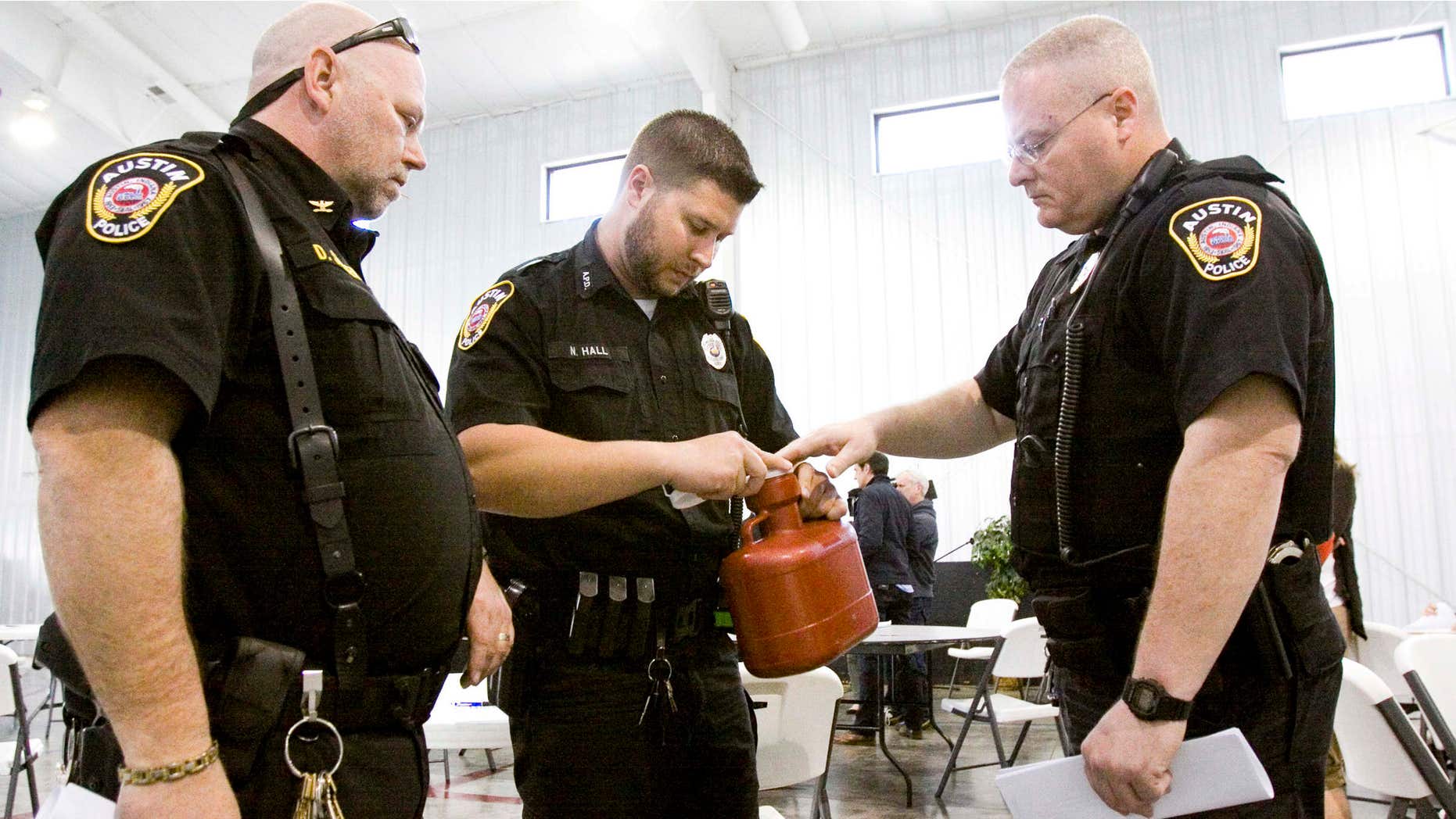 April 1, 2015: Austin Police Chief Donald Spicer, left, and Patrolman Nathan Hall, center, and Maj. Lonnie Noble study a biohazard container for the temporary disposal of needles and other sharp objects at an HIV/AIDS training session in Austin, Indiana.