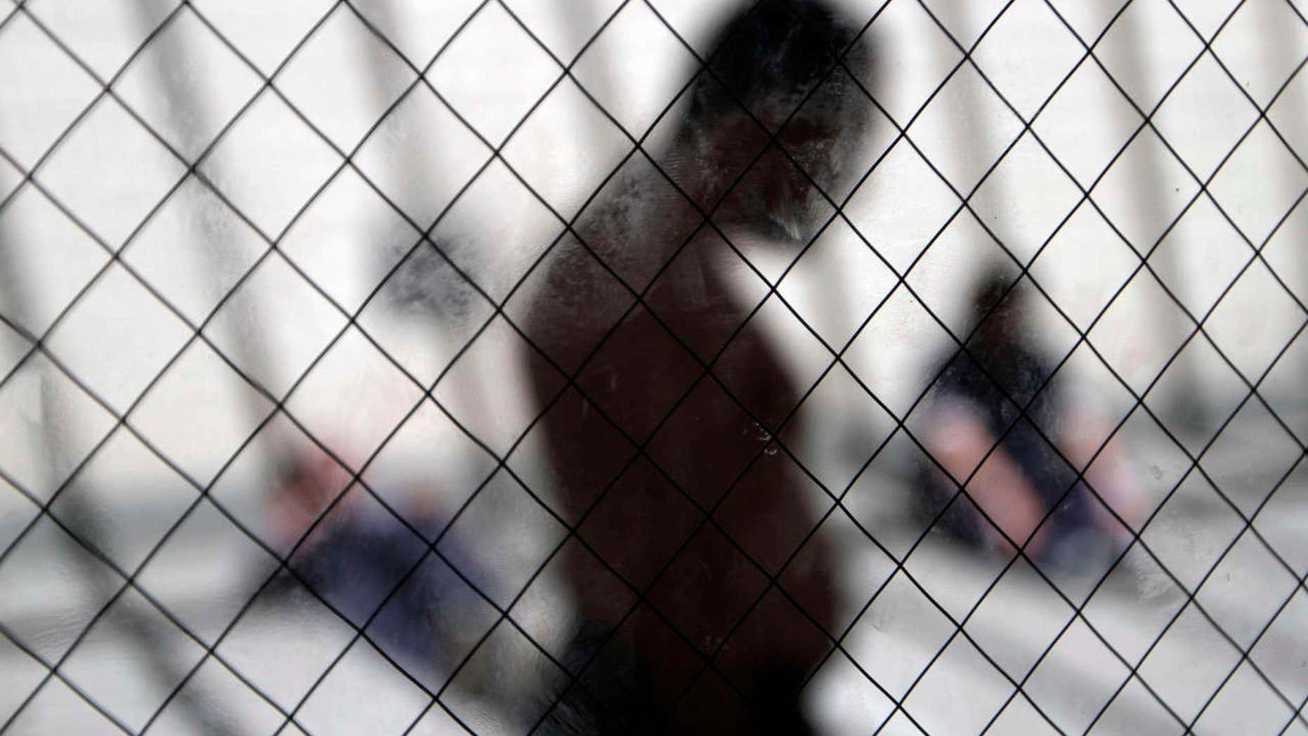 FILE - In this May 26, 2010 file photo men sit in the sun in a room for mental health patients in the health ward at the Otay Mesa immigration detention center in San Diego.